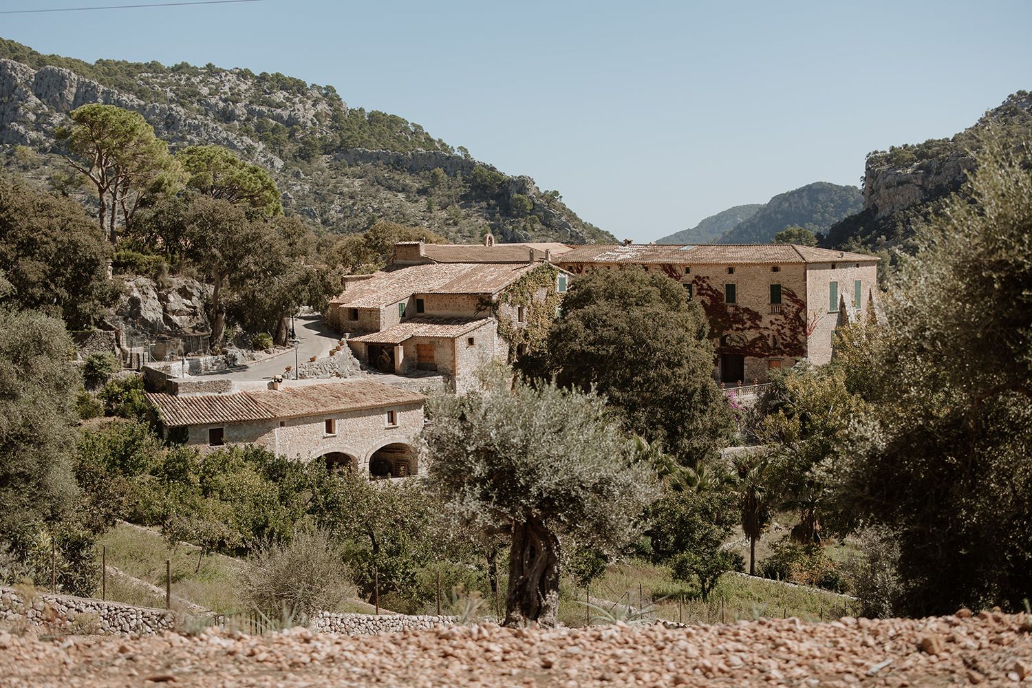 Traditional stone buildings nestled in a mountainous Mediterranean landscape.