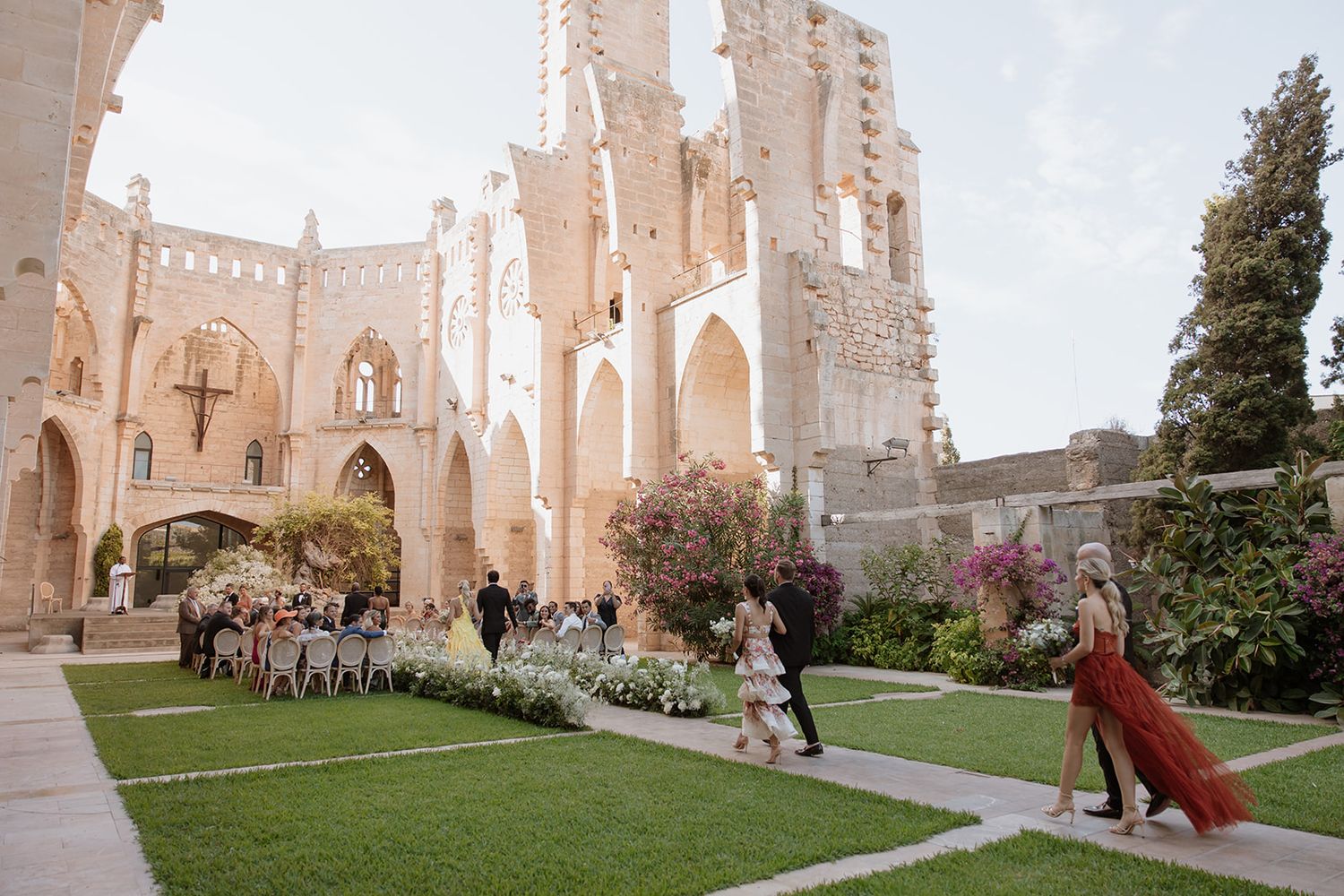 Wedding venue in gothic cathedral ruins with stone archways and flowering gardens.