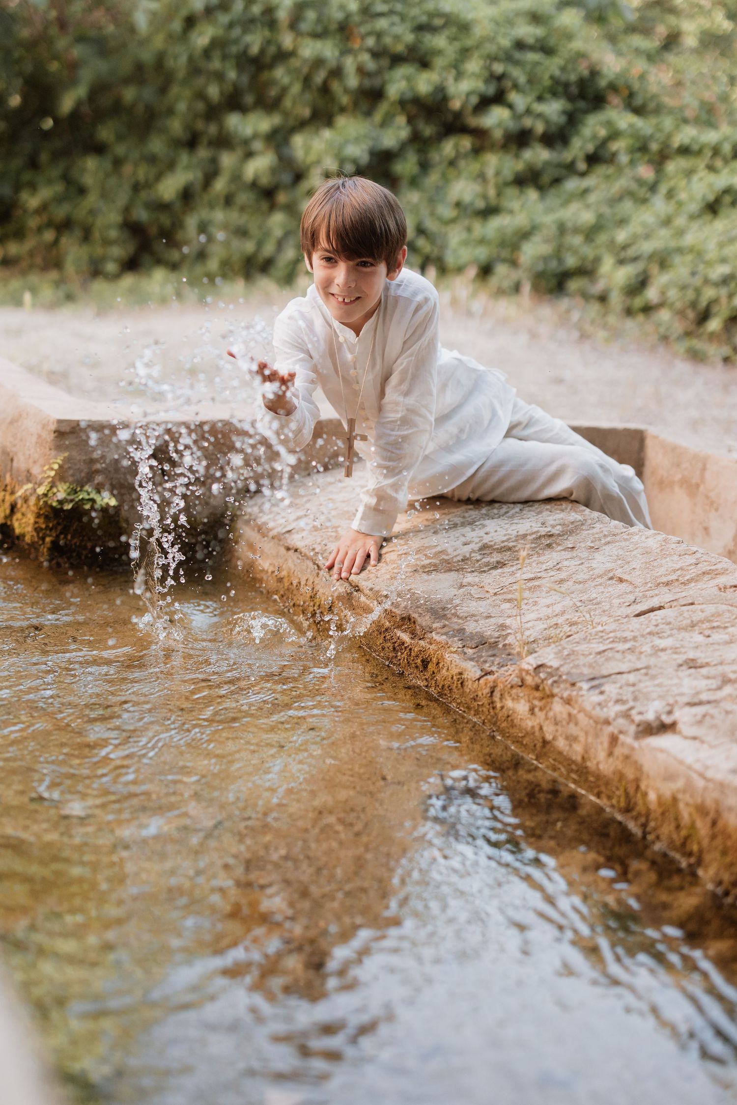 A sequence of images showing joyful splashing and playful moments by the water's edge in a natural outdoor setting.