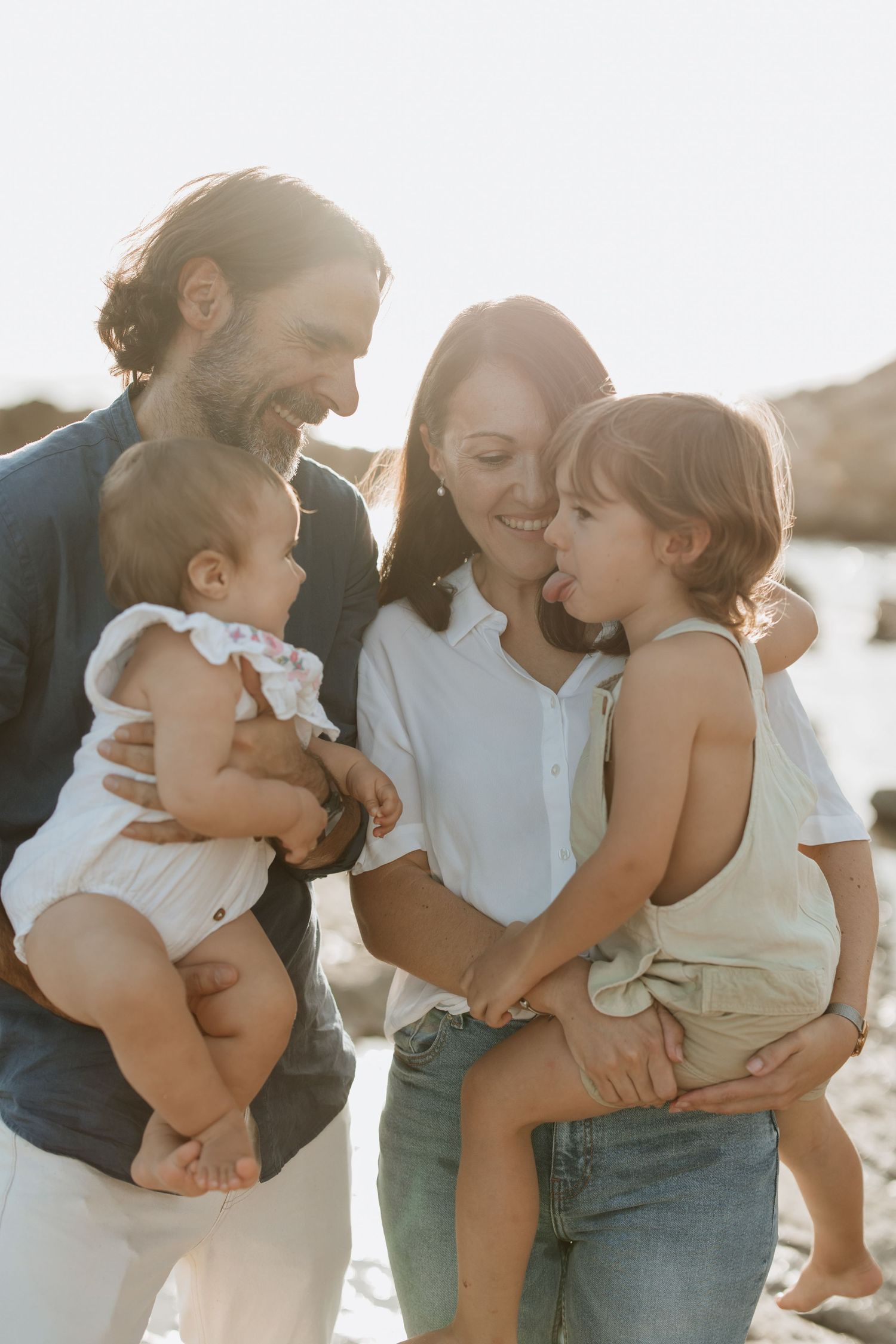 A family of four sharing loving moments together by the seaside.