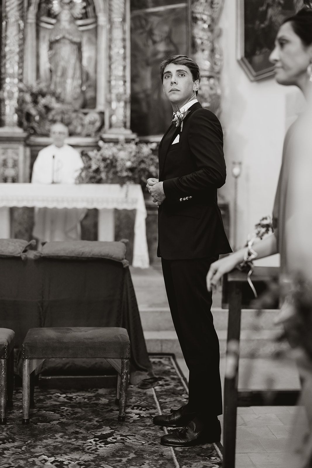 Church ceremony with ornate altar and traditional religious decor in black and white.