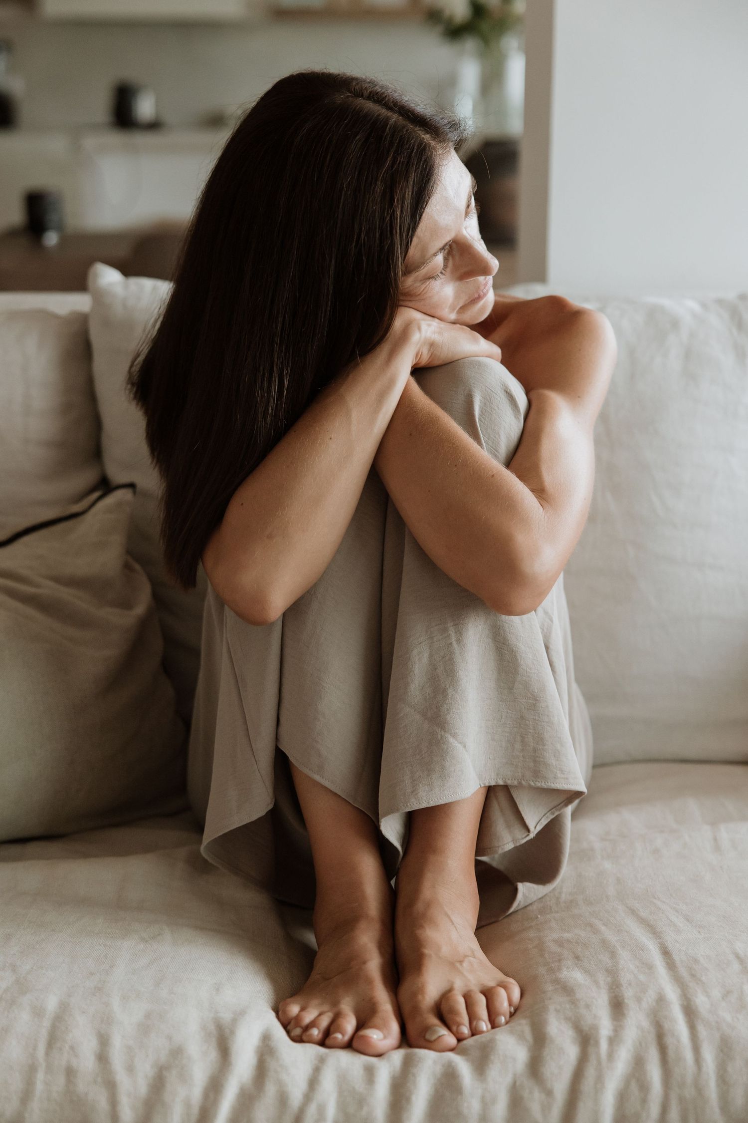 Minimalist lifestyle photograph of person relaxing on white sofa.