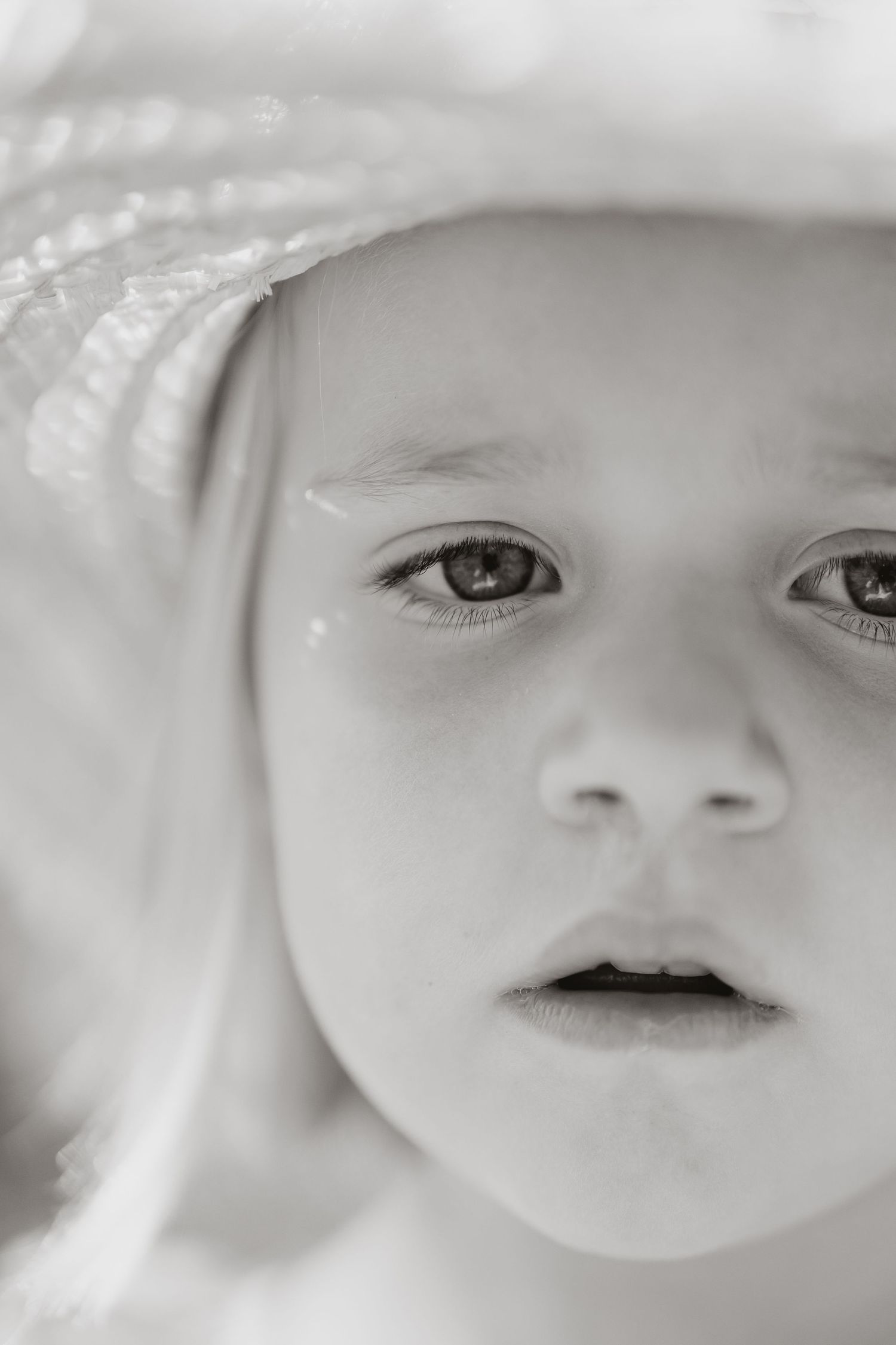 Ethereal black and white close-up portrait capturing soft lighting and delicate features.