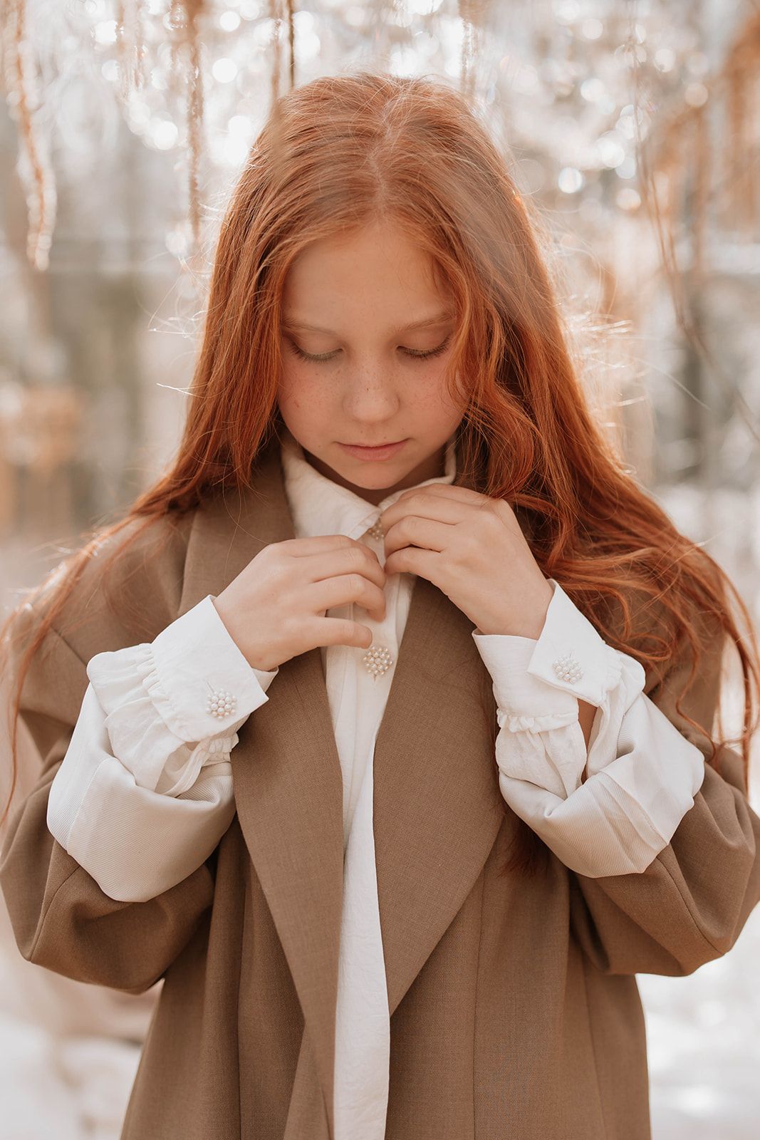 Soft portrait in warm tones featuring long auburn hair and elegant vintage-inspired clothing.