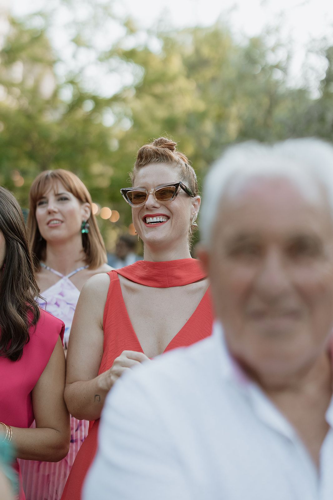 Wedding guests enjoying the celebration in colorful attire during an outdoor reception.