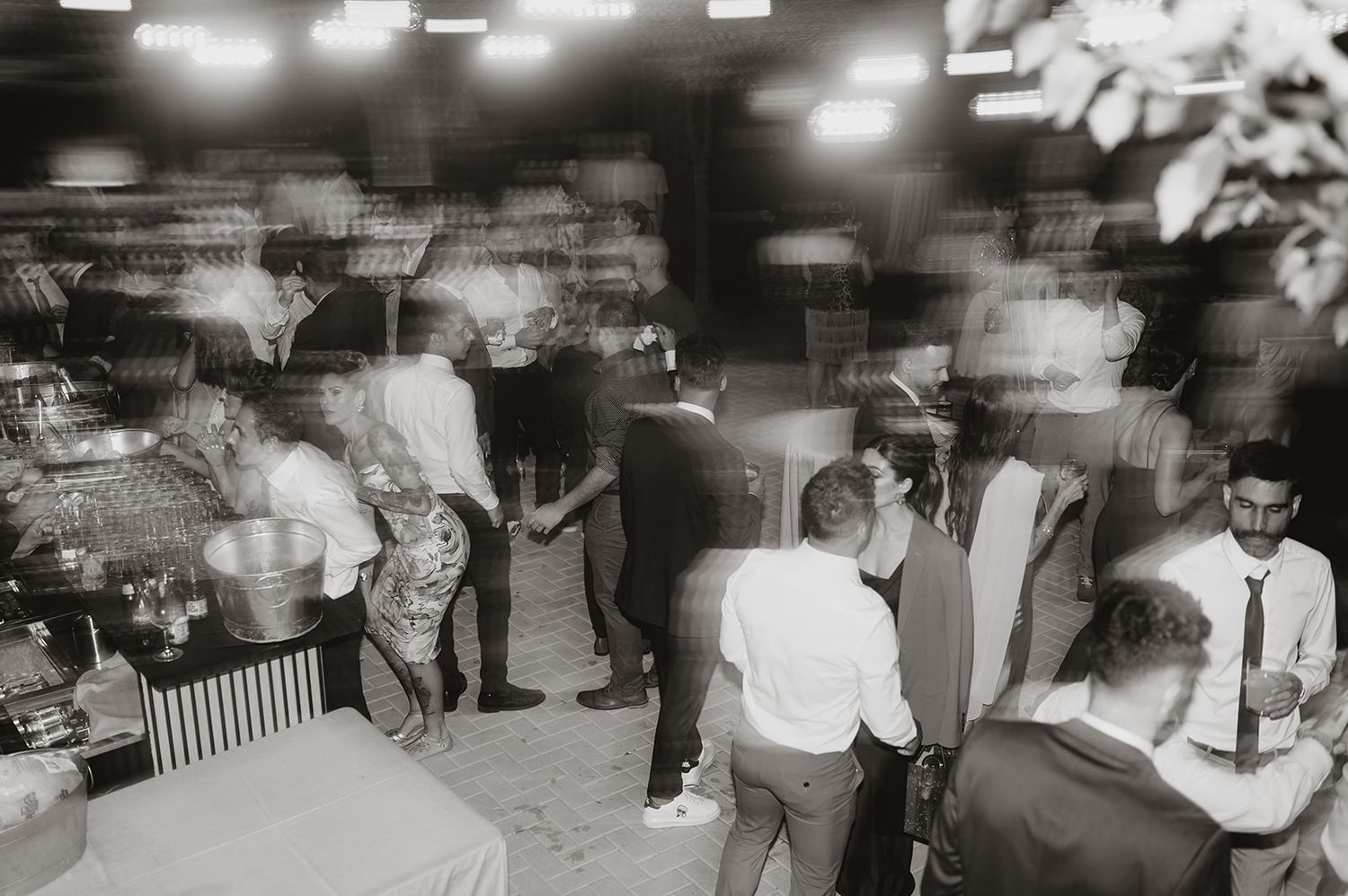 Black and white photo of guests mingling at an evening reception.