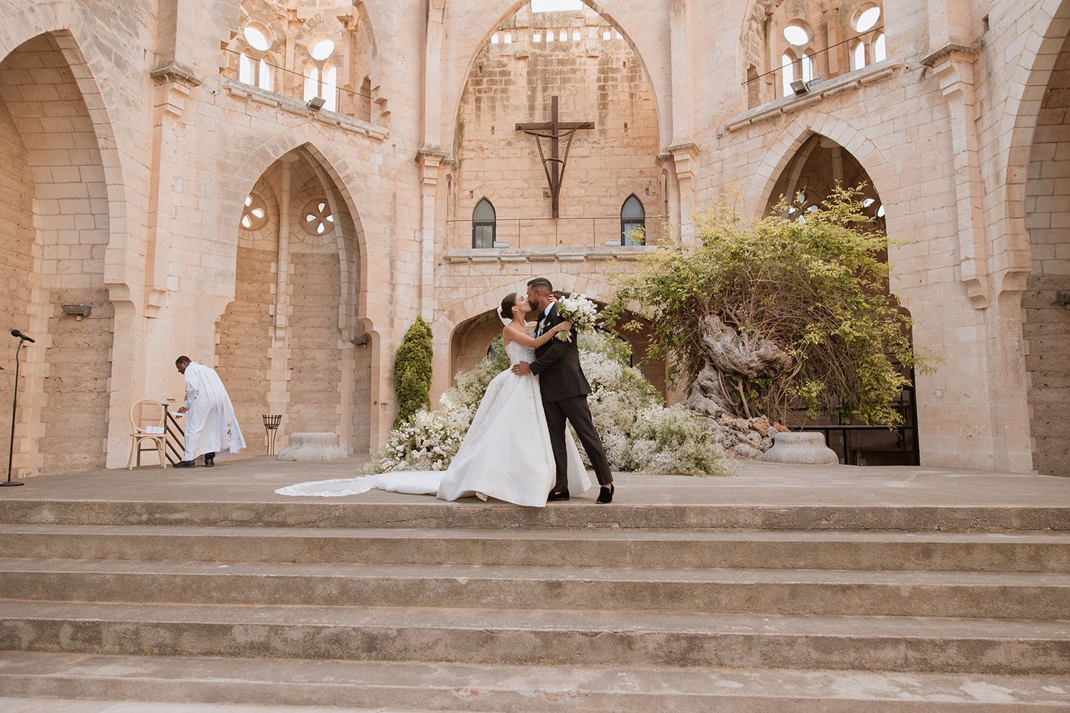 Romantic dance moment captured in a historic church courtyard with stone architecture.