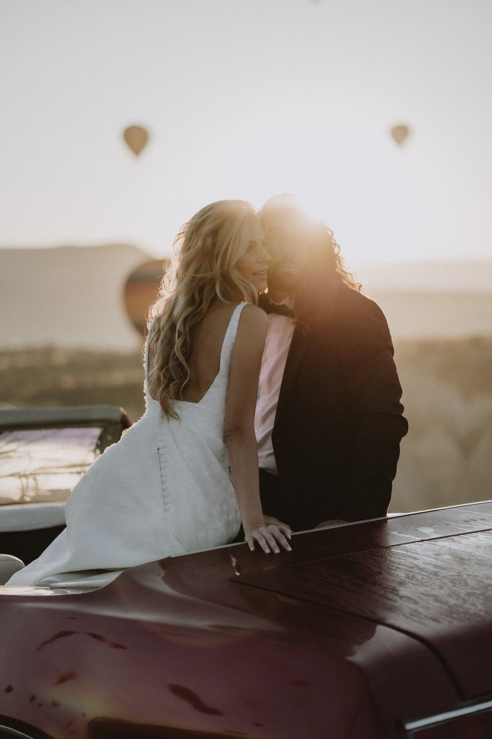 Romantic sunset silhouette of couple sitting together on their wedding day.