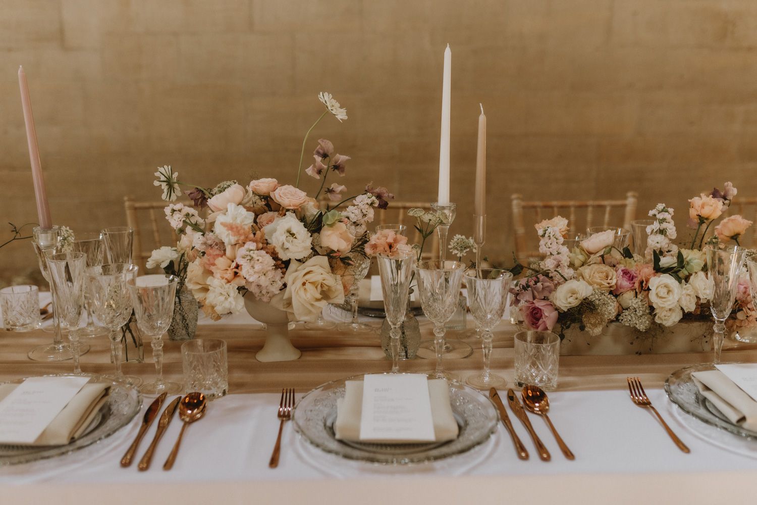 Elegant wedding table setting with neutral floral arrangements and place settings.