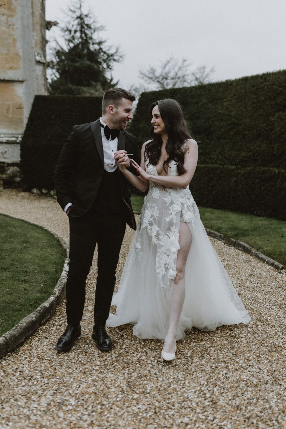 A sweet moment shared on a gravel pathway with formal garden hedges in the background.