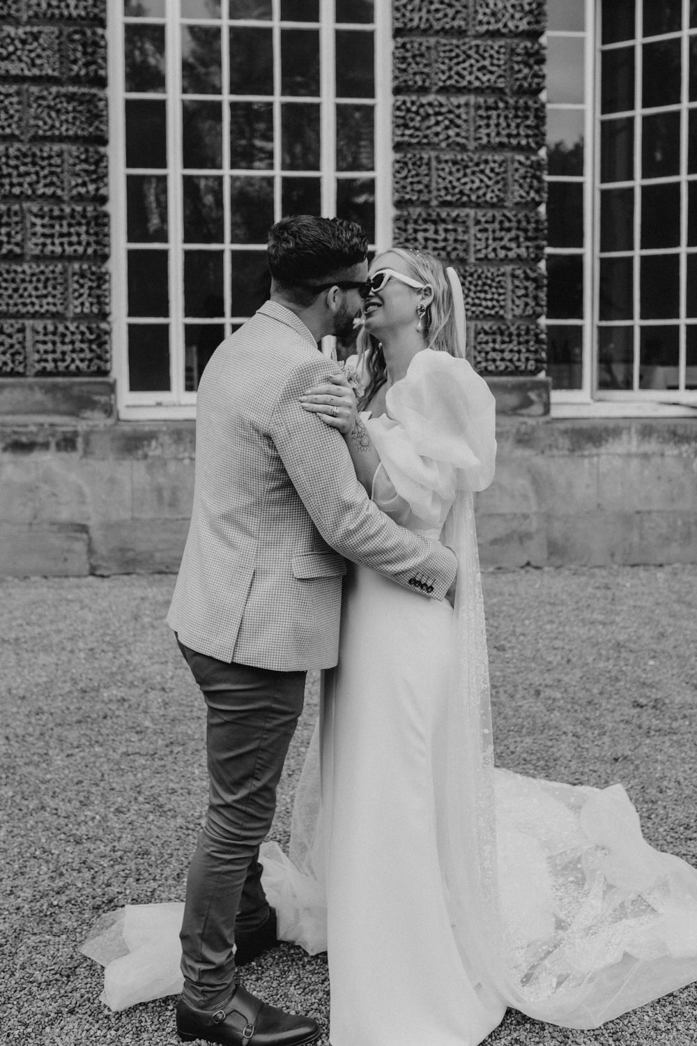 Intimate black and white moment between newlyweds outside historic venue.