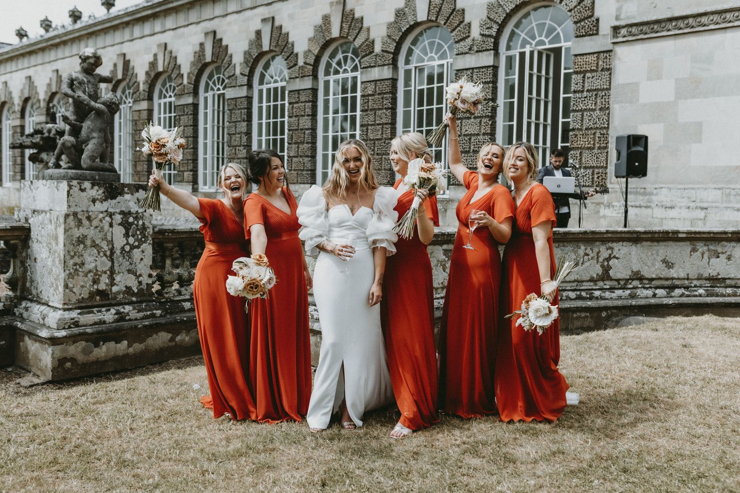 Bridal party celebrating outside a grand historic building with ornate architecture.