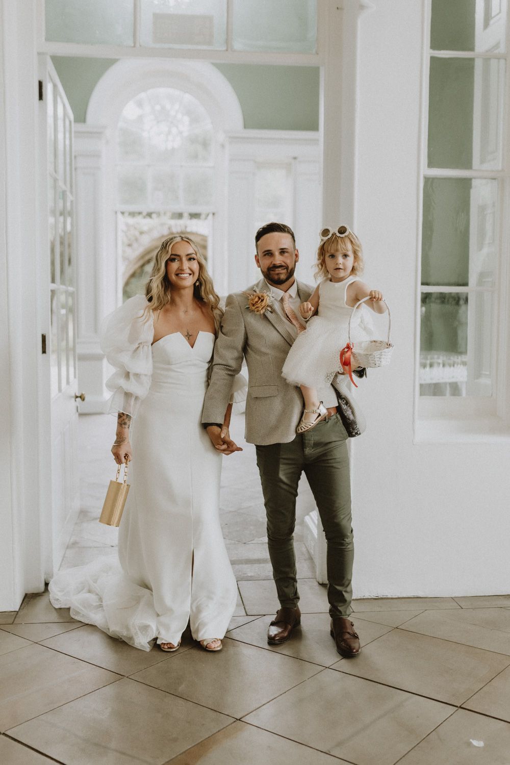 Wedding party portrait in elegant white interior with beautiful architectural details and natural light.