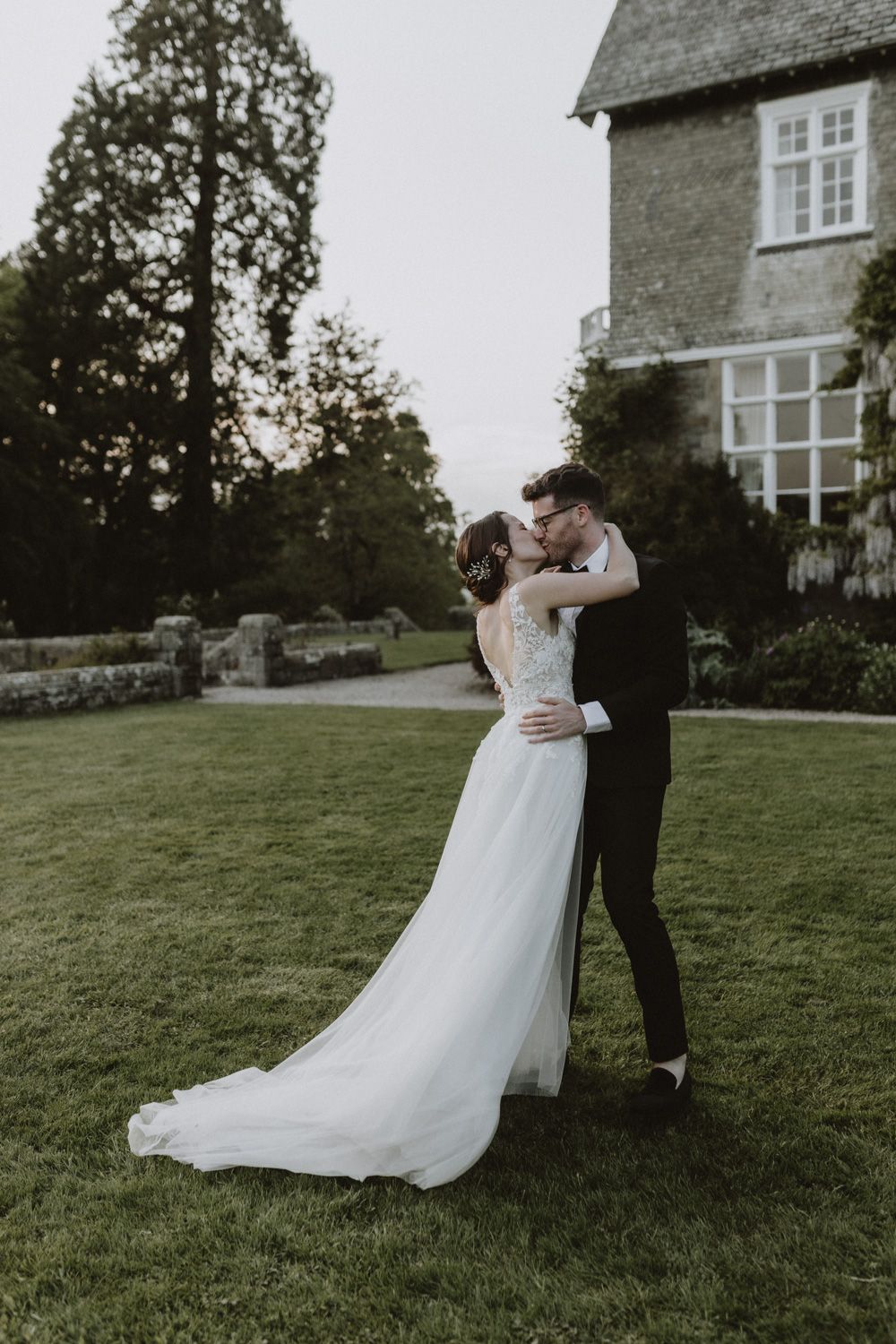 Romantic dance sequence captured on the lawn of a historic stone estate.