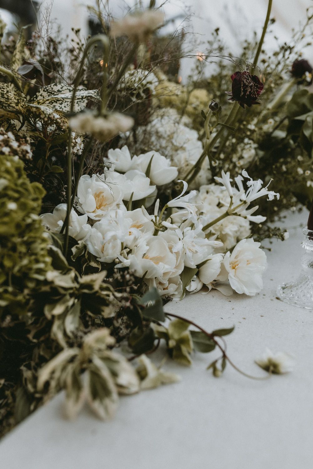 Delicate white flowers and greenery arranged in a romantic garden-style wedding decoration.