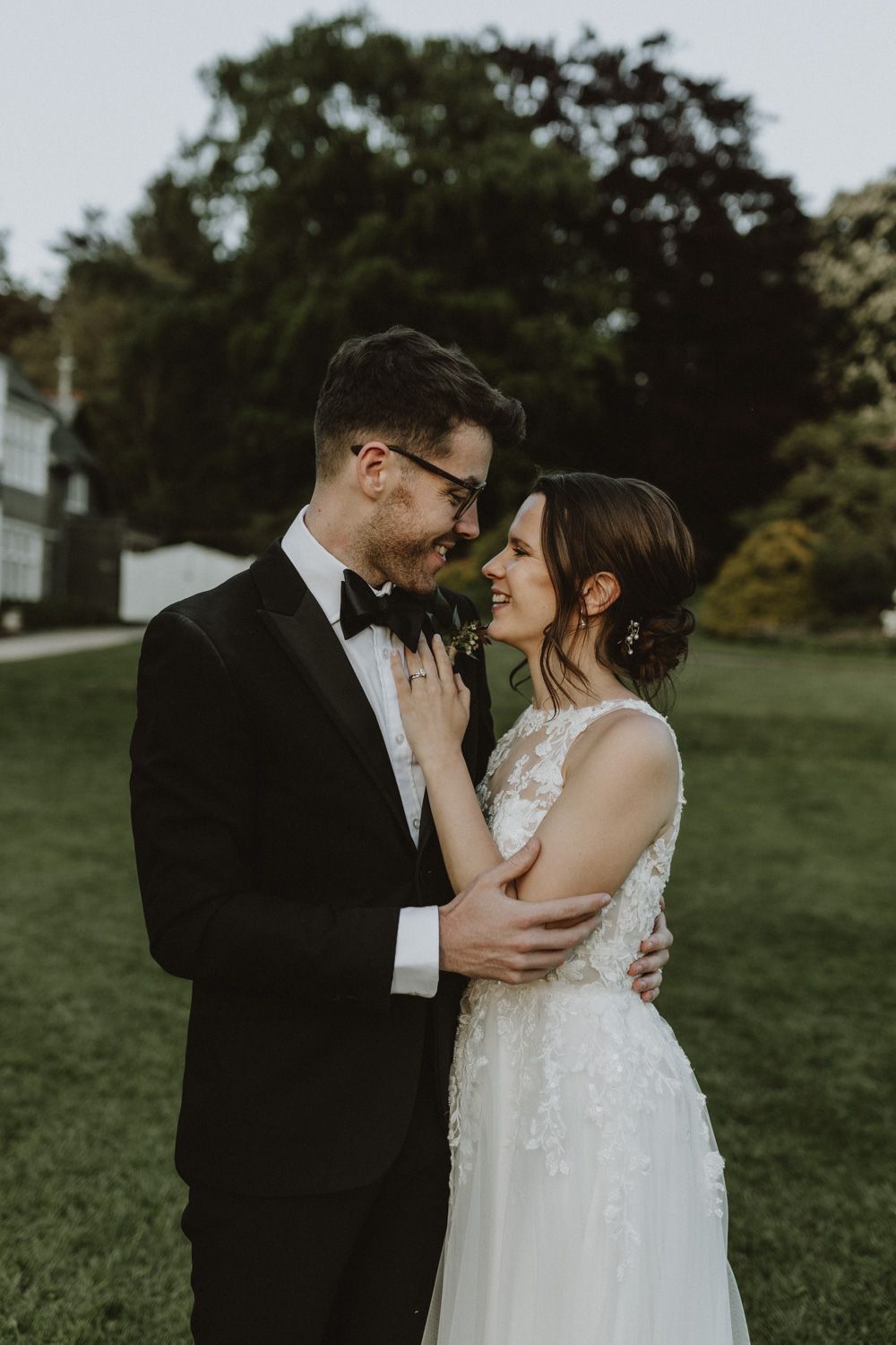 Intimate wedding portrait captured on a lush green lawn during golden hour.