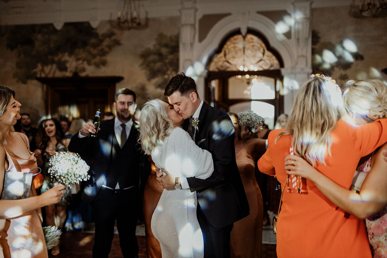 A joyous wedding celebration moment captured indoors with guests gathered around.