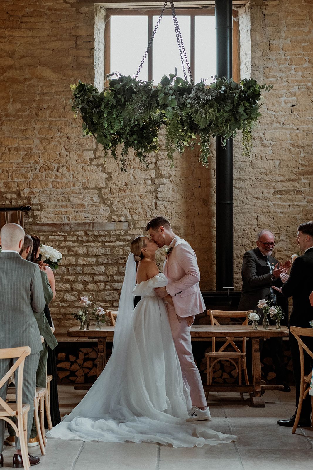 A series of candid moments during a rustic wedding, featuring a couple interacting in a brick-walled venue with hanging plants.