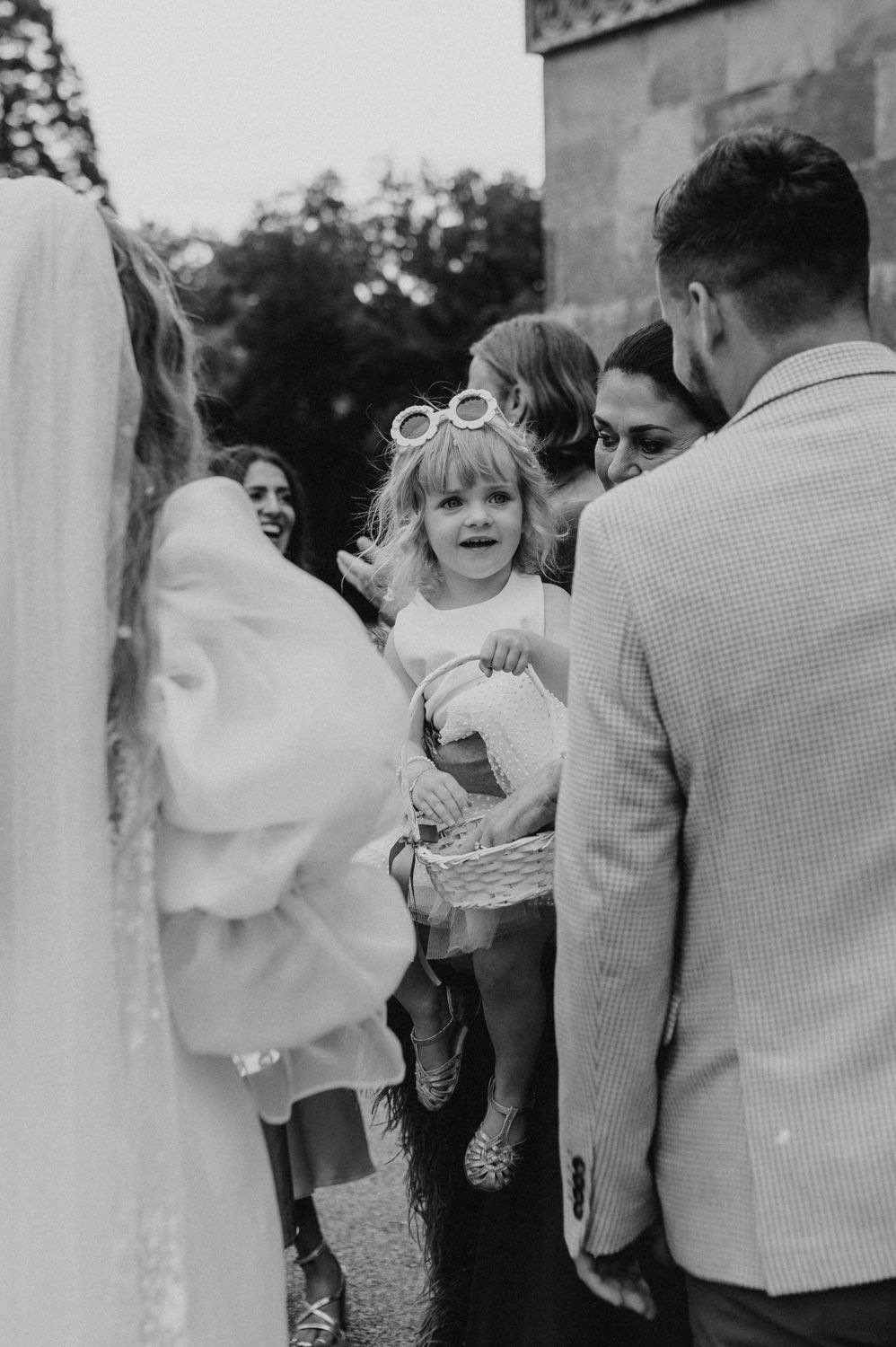 Black and white candid moment captured during wedding celebration outdoors.