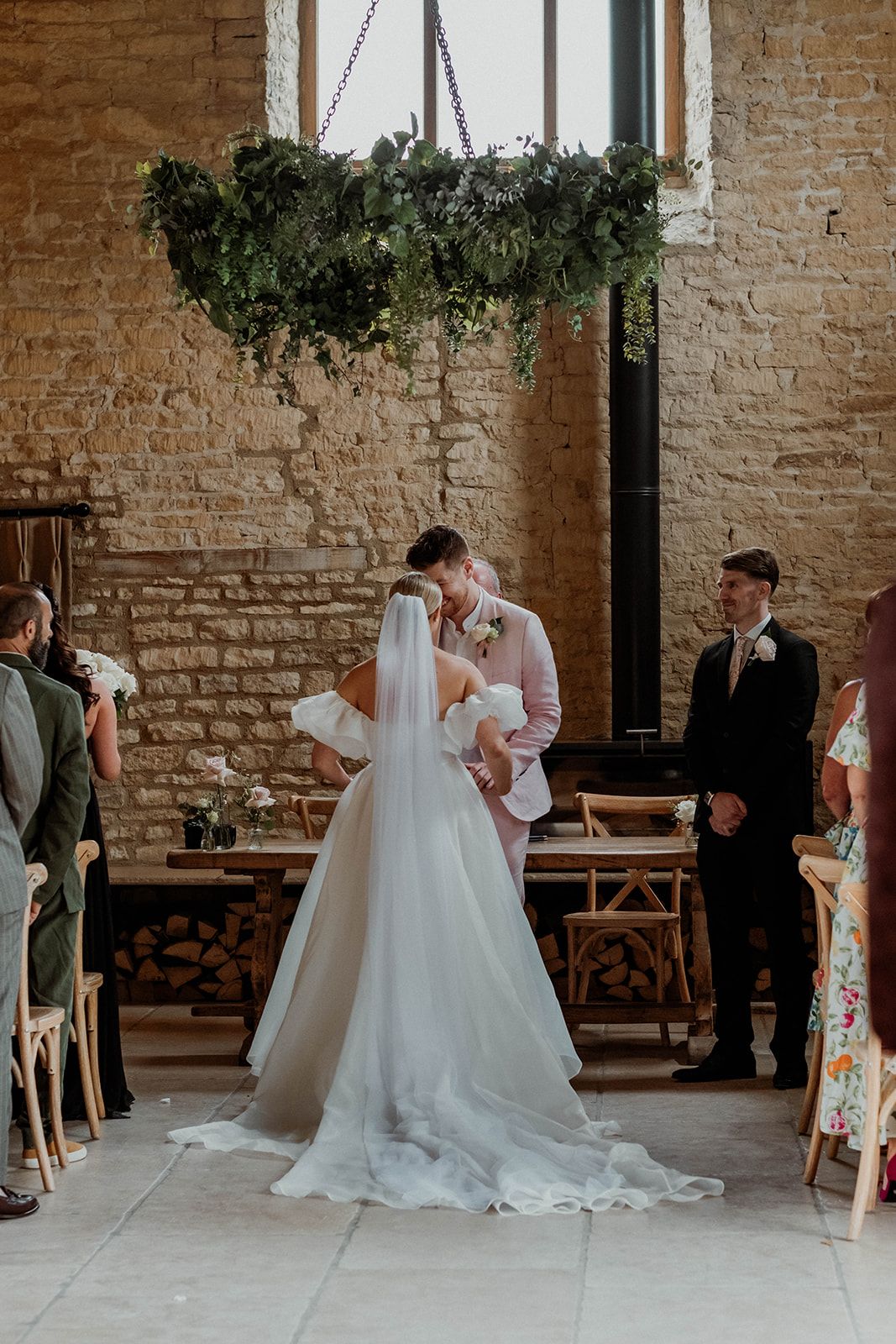 A romantic first look sequence between a bride in a white gown and groom at a rustic brick venue.