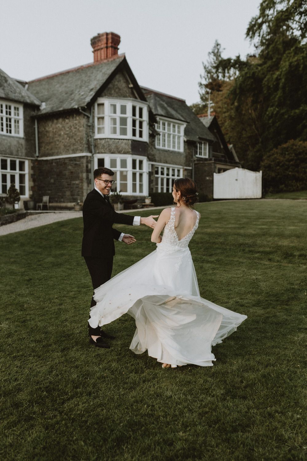 Bride's dress twirls gracefully during an outdoor dance on the mansion grounds.