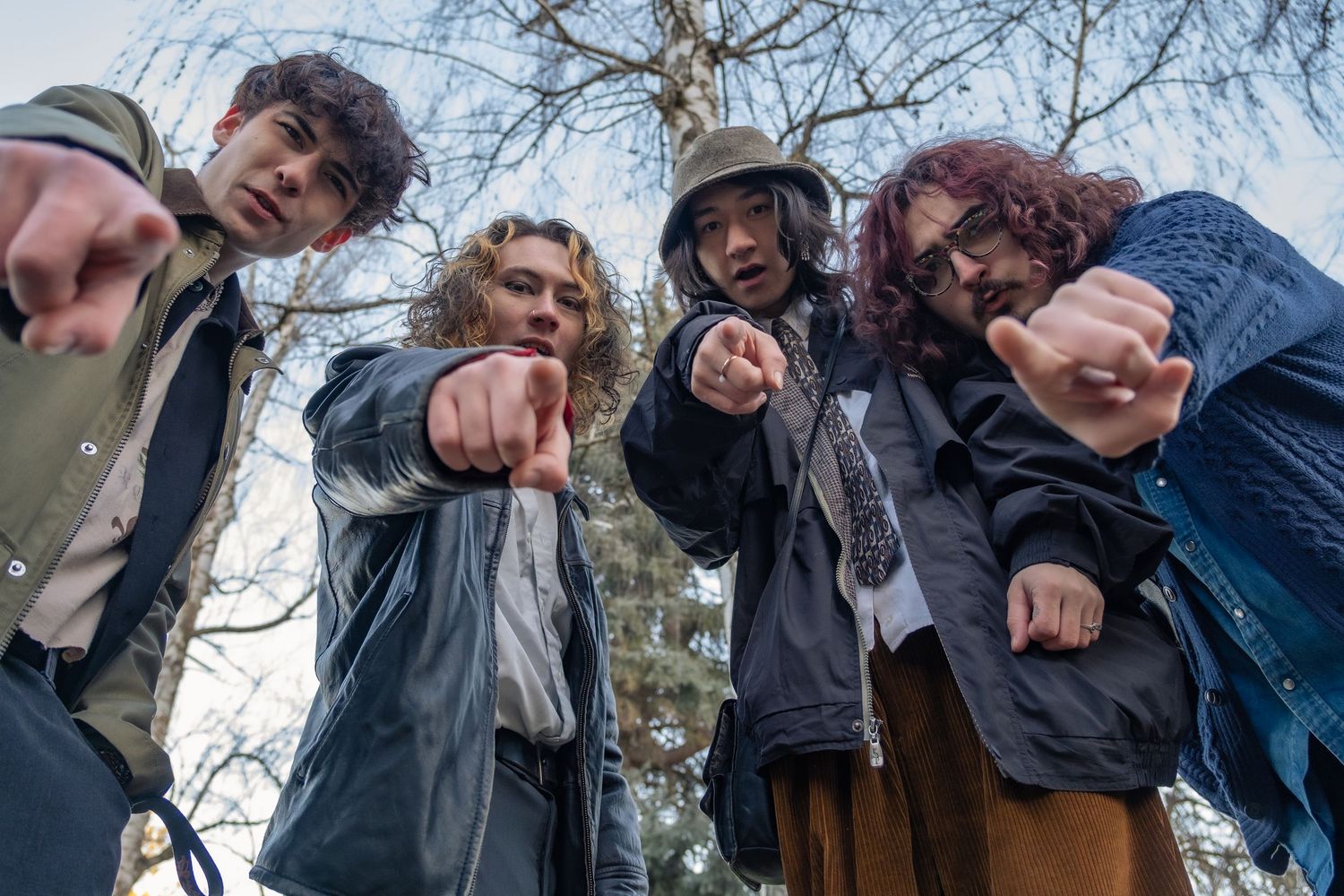 Low angle view of people looking down at camera while standing in a circle outdoors during winter.