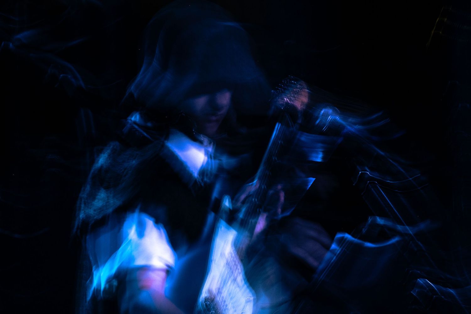 Abstract blue and purple light trails create a dynamic motion effect against a dark background.