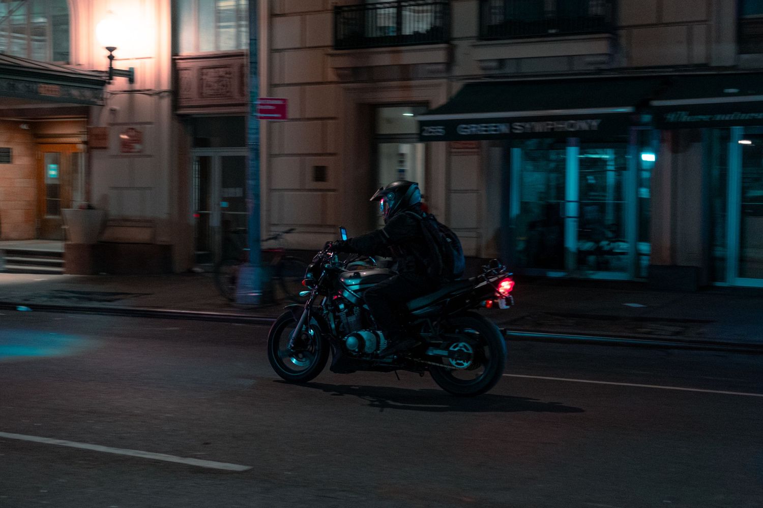 Cinematic urban street scene at dusk with glowing traffic lights and buildings in moody blue tones.