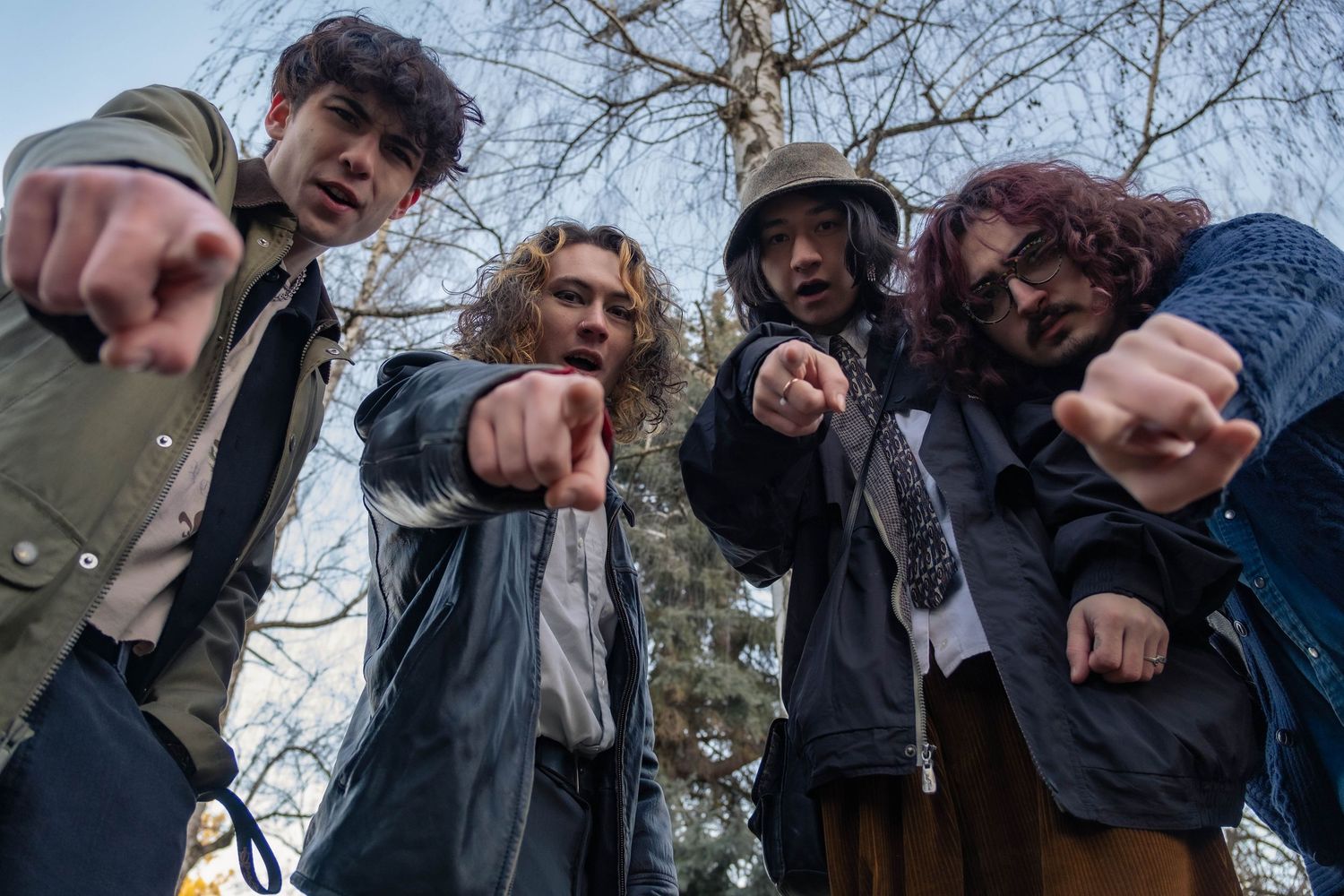 Group points their fingers at the camera while posing outdoors.