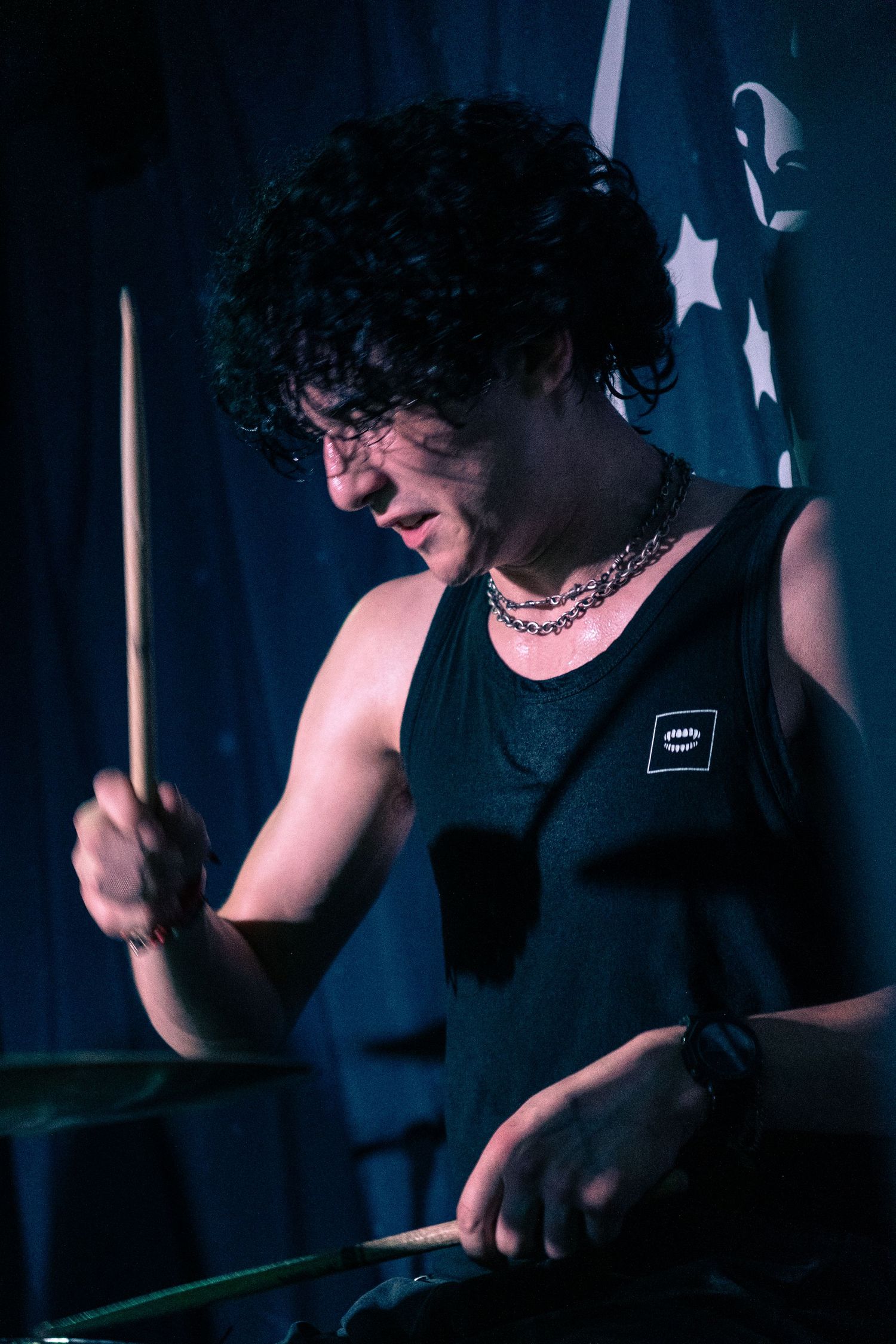 Drummer performing in dark lighting with dramatic shadows and dynamic movement captured across multiple frames.