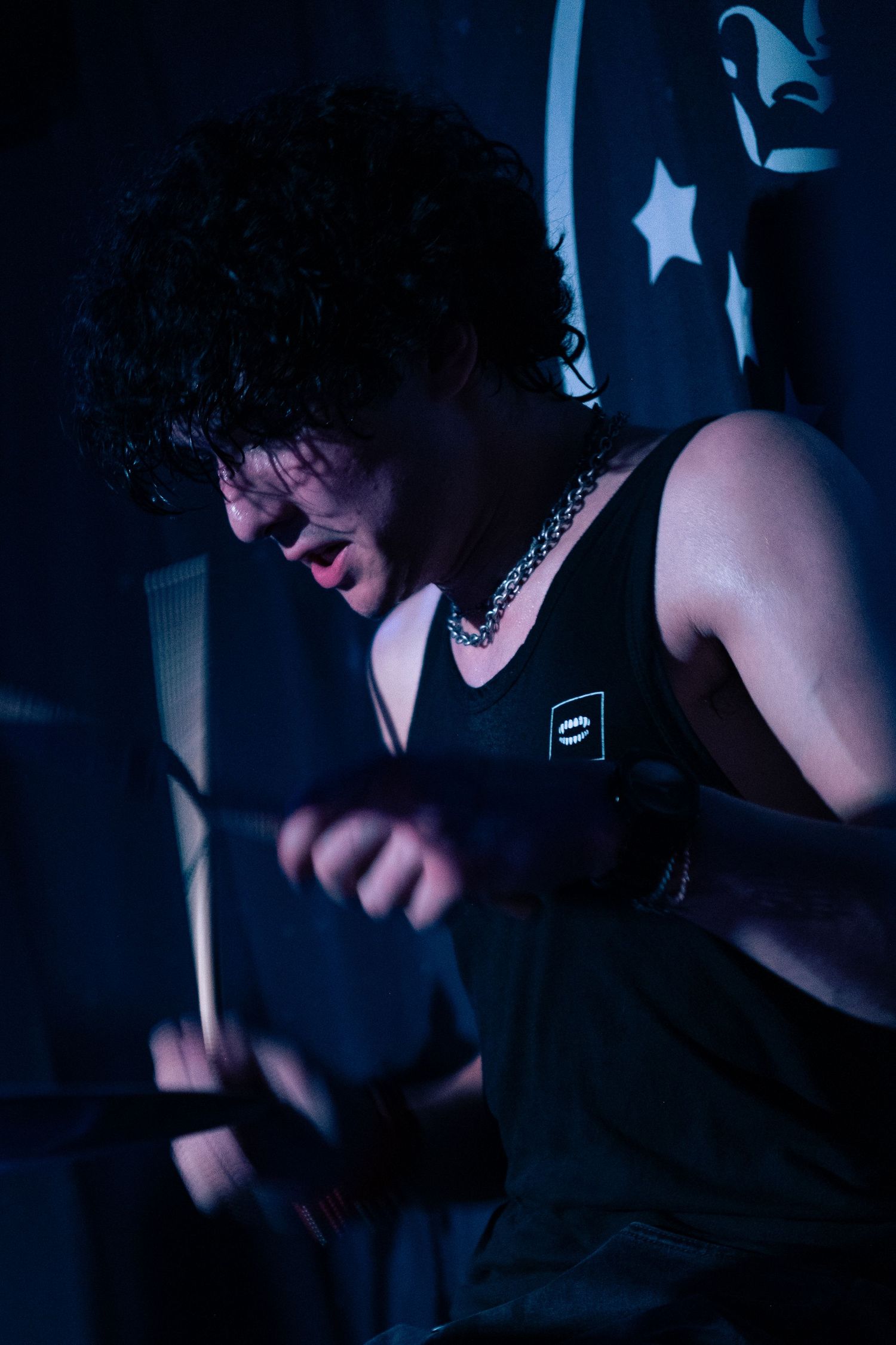 A series of dark, moody portraits showing someone playing guitar in dramatic low-key lighting with blue tones.