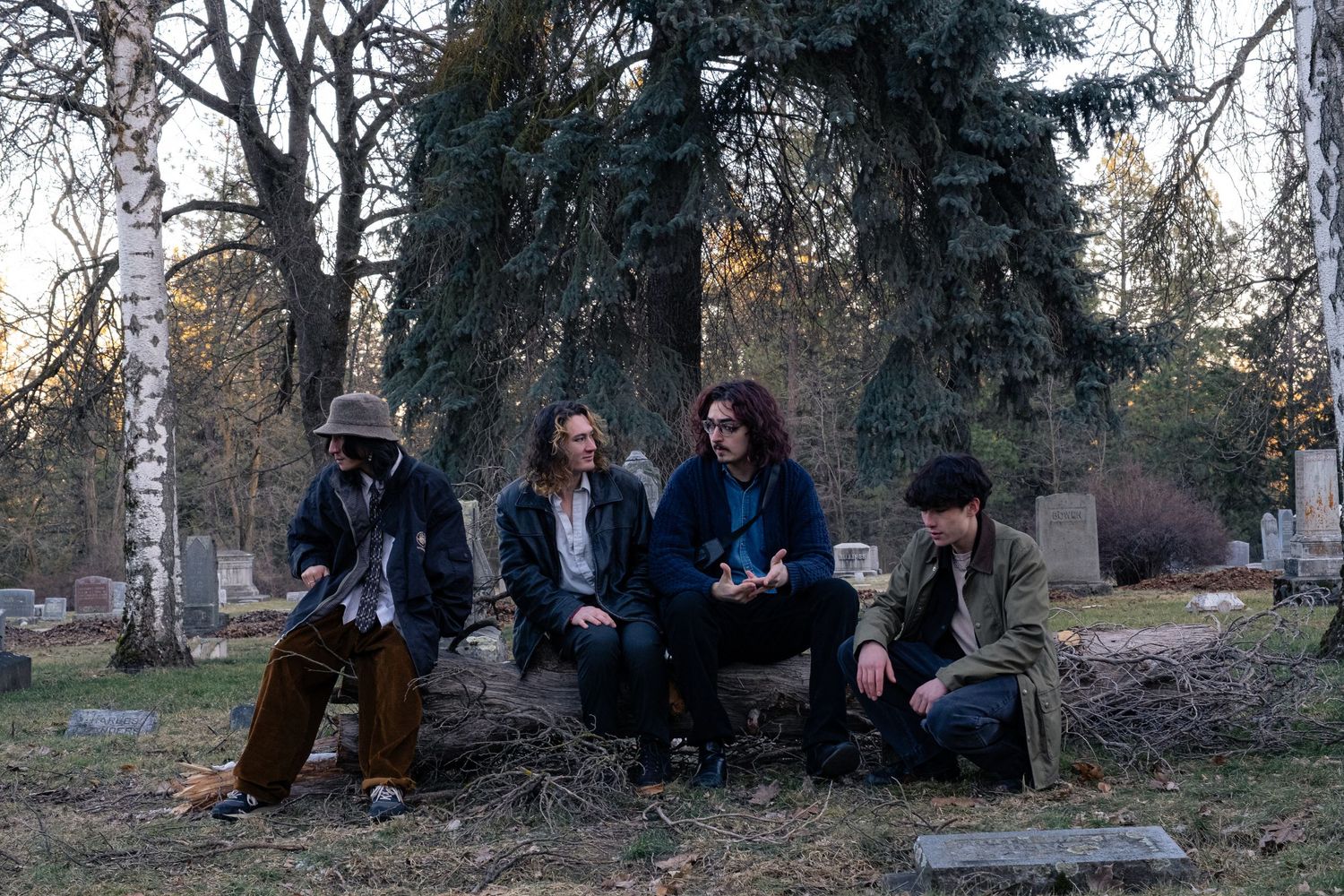 A group of people sitting and relaxing together outdoors in a park setting during autumn.