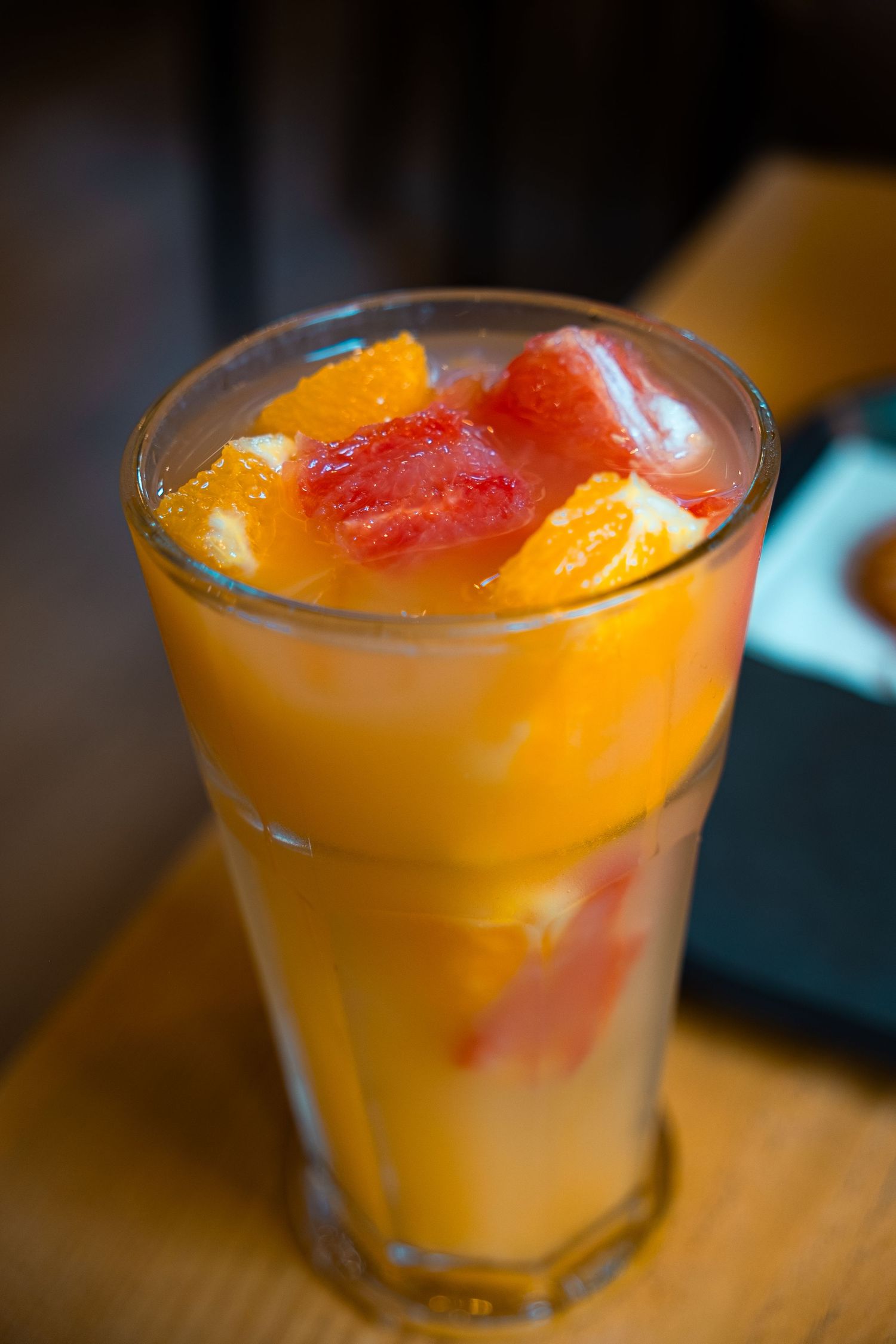 Tropical orange tea garnished with fresh citrus slices in a rocks glass.