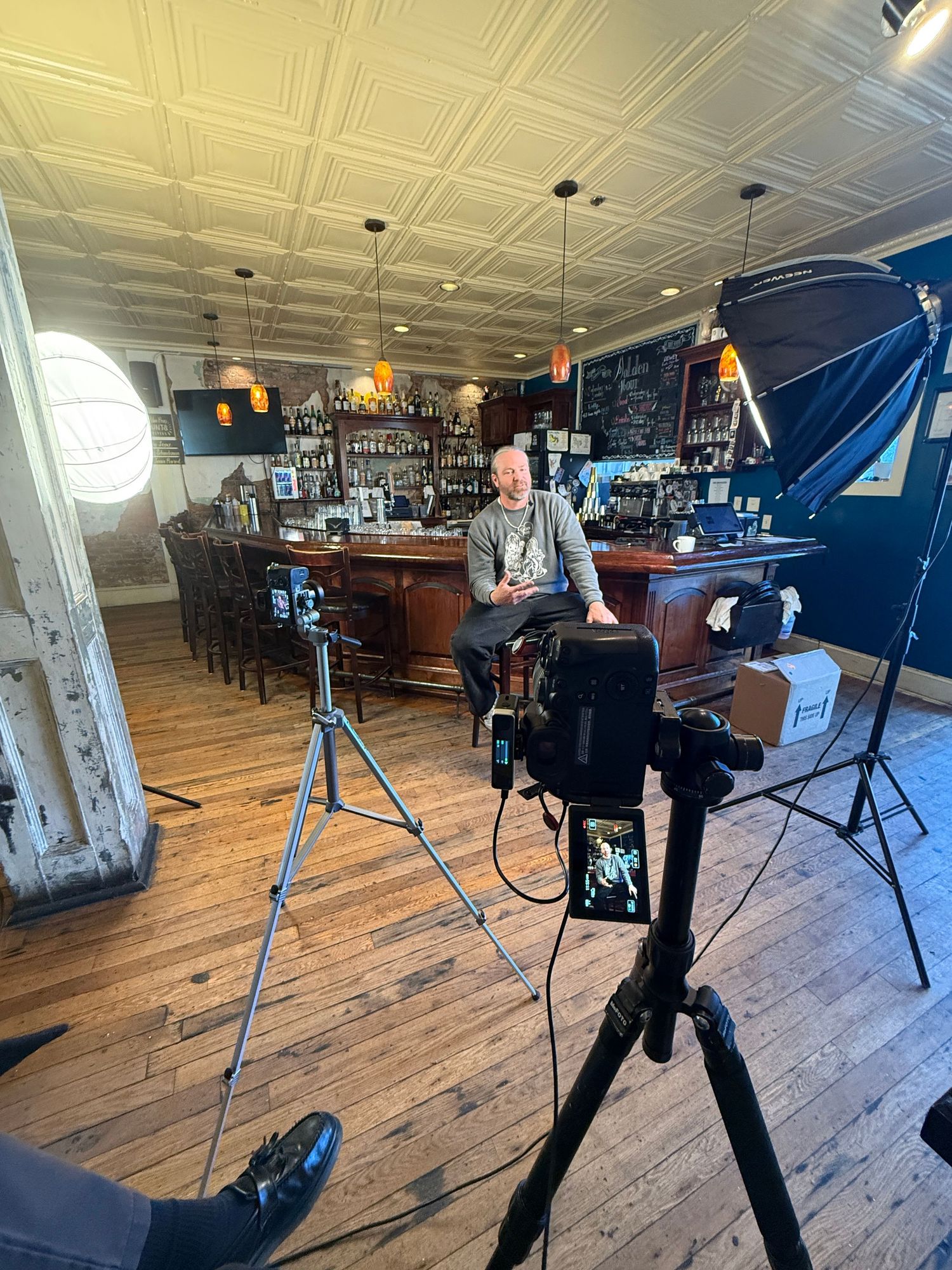Professional photography studio setup with lighting equipment and wooden flooring.