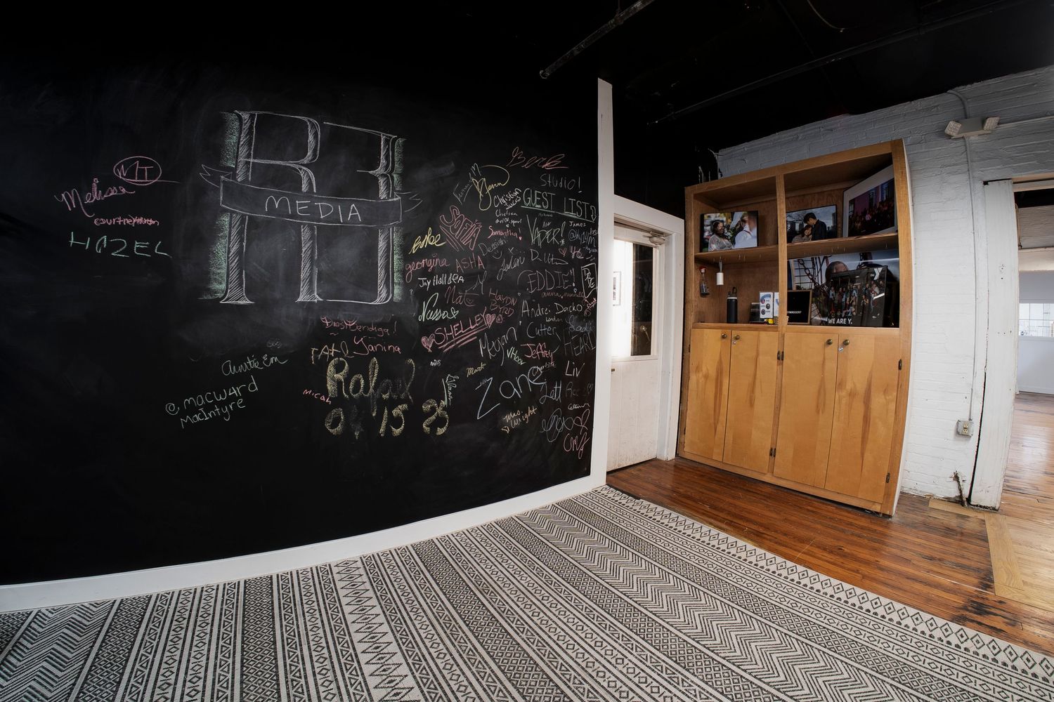 Time-lapse view of modern classroom with dark chalkboard walls and hardwood floors showing natural light movement.