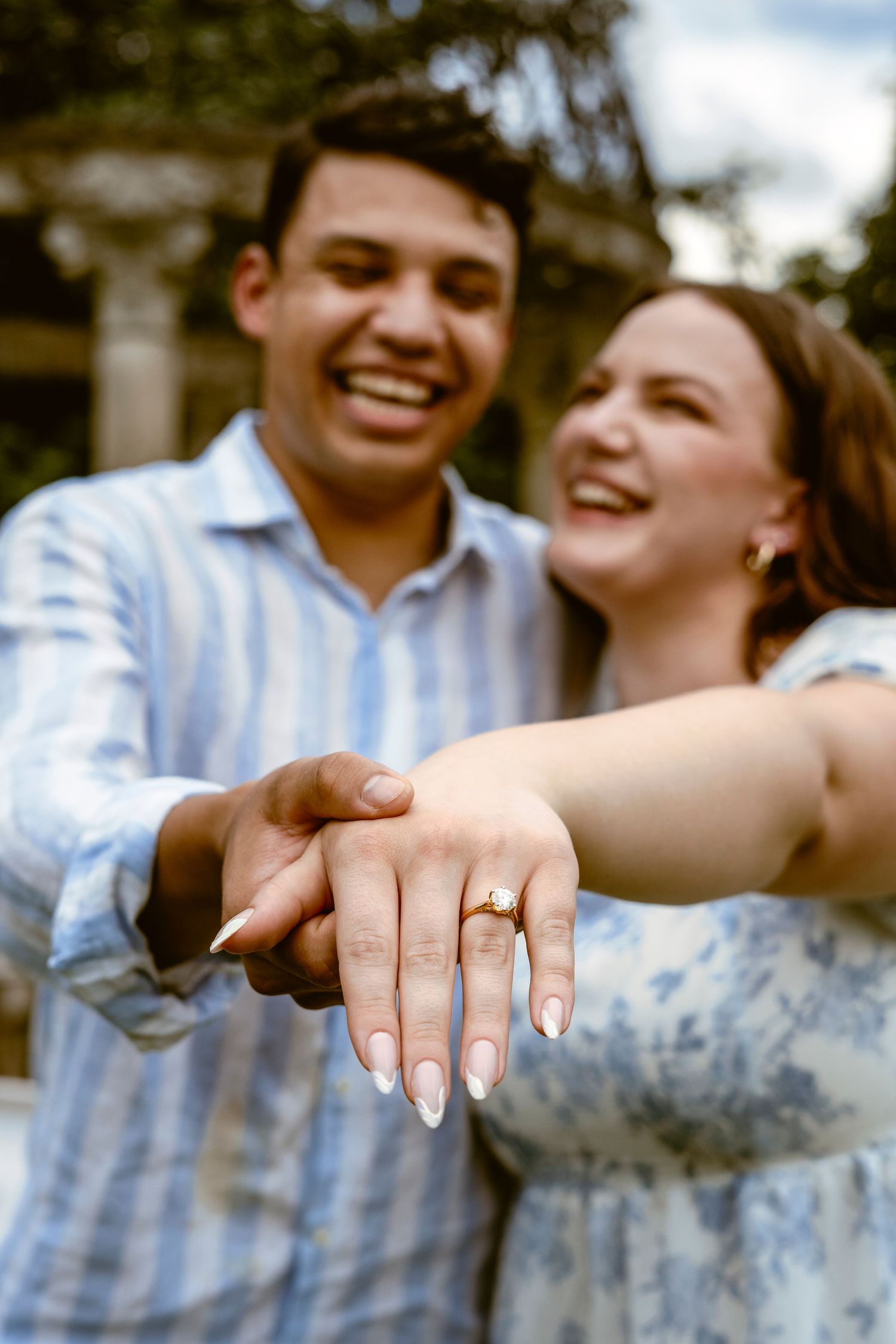 A couple shows off an engagement ring in a series of close-up photos displaying the ring on their hand.