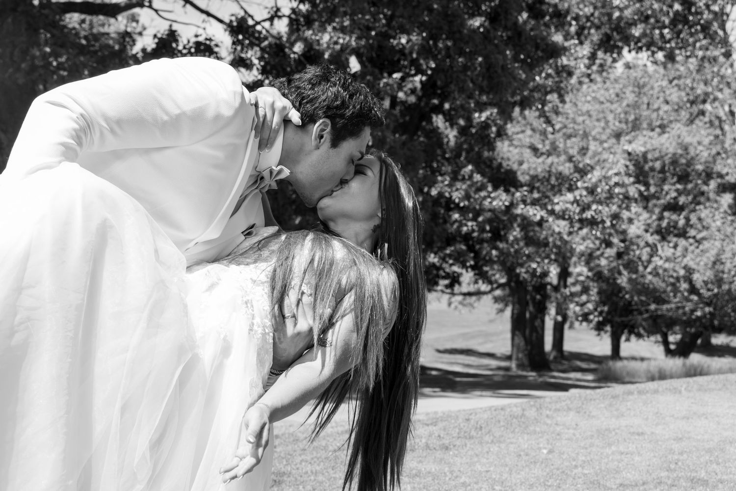 Black and white photo collage of a couple in romantic poses during their outdoor wedding celebration.