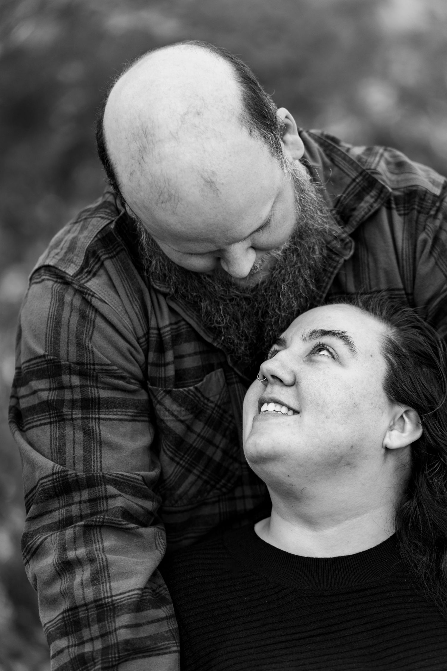 A couple shares intimate laughter and joy in a series of black and white candid portrait photos.