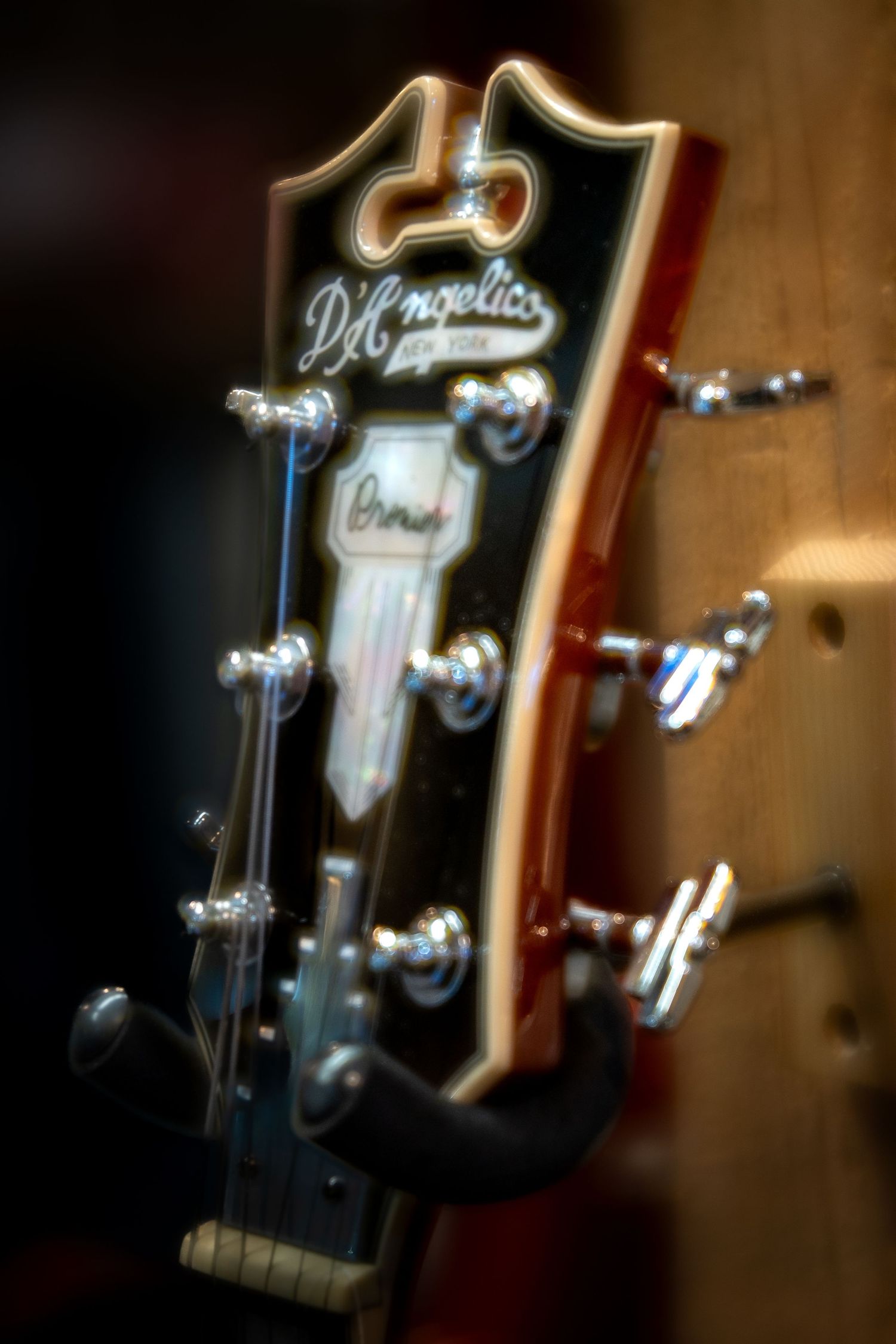 Close-up of a D'Angelico New York archtop guitar headstock with chrome tuning pegs.