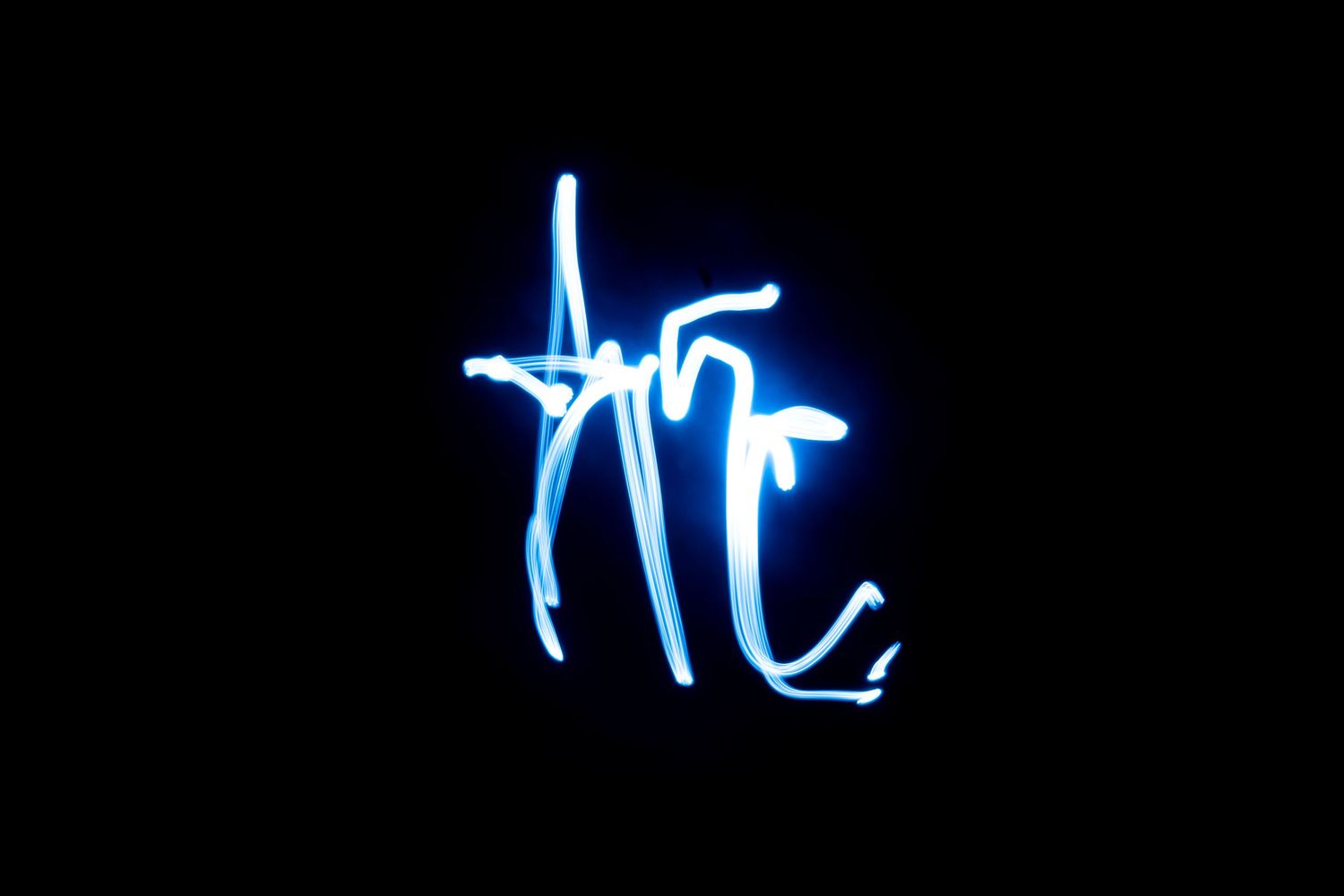 Blue light painting art on black background, glowing neon calligraphy letters created with long exposure photography.