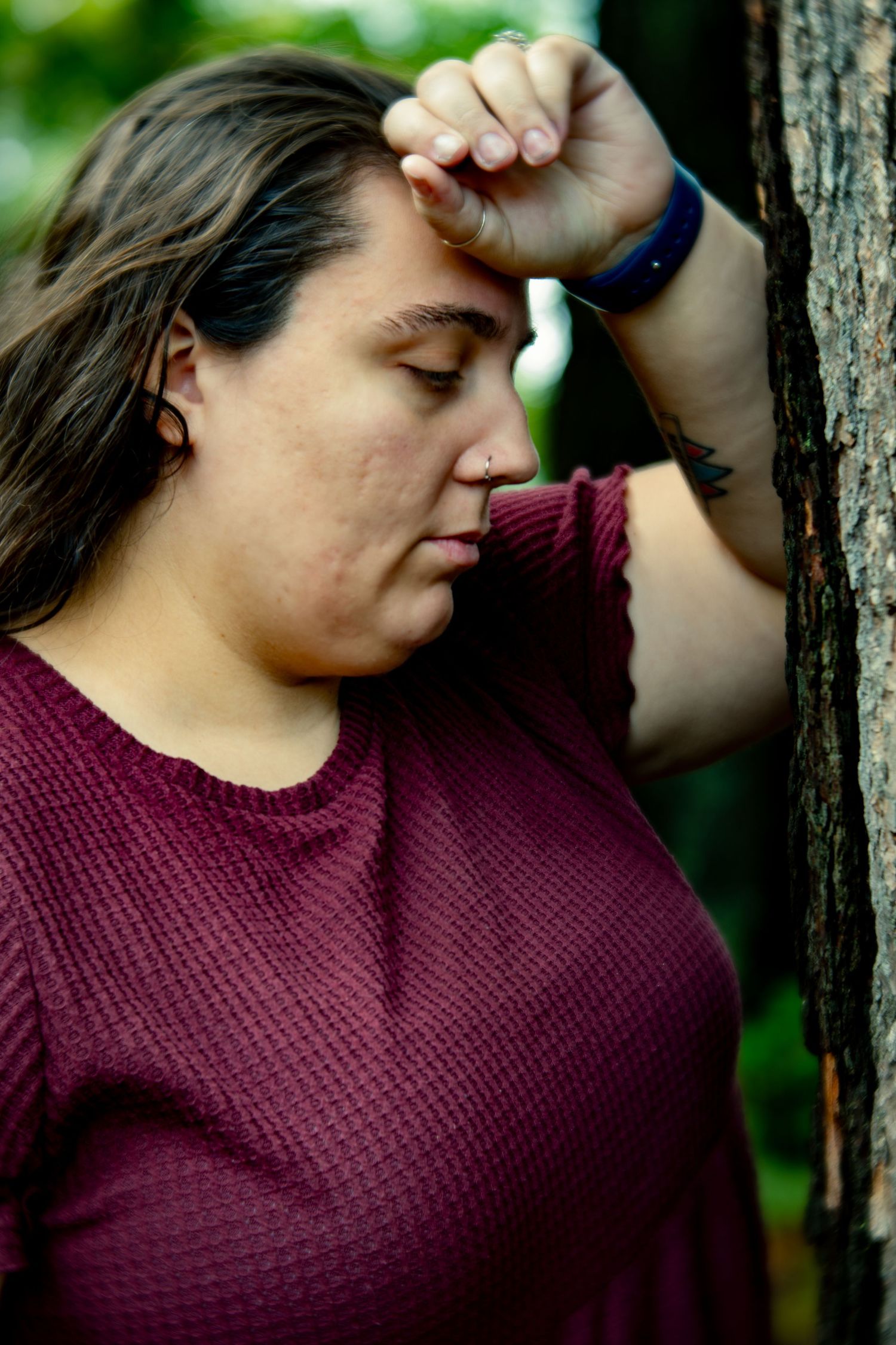 A contemplative moment captured in profile against a natural forest background.