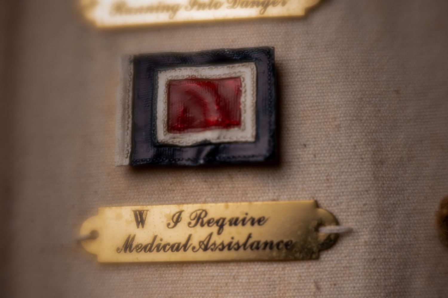 Vintage nautical signal flag W meaning I Require Medical Assistance displayed on aged fabric background.