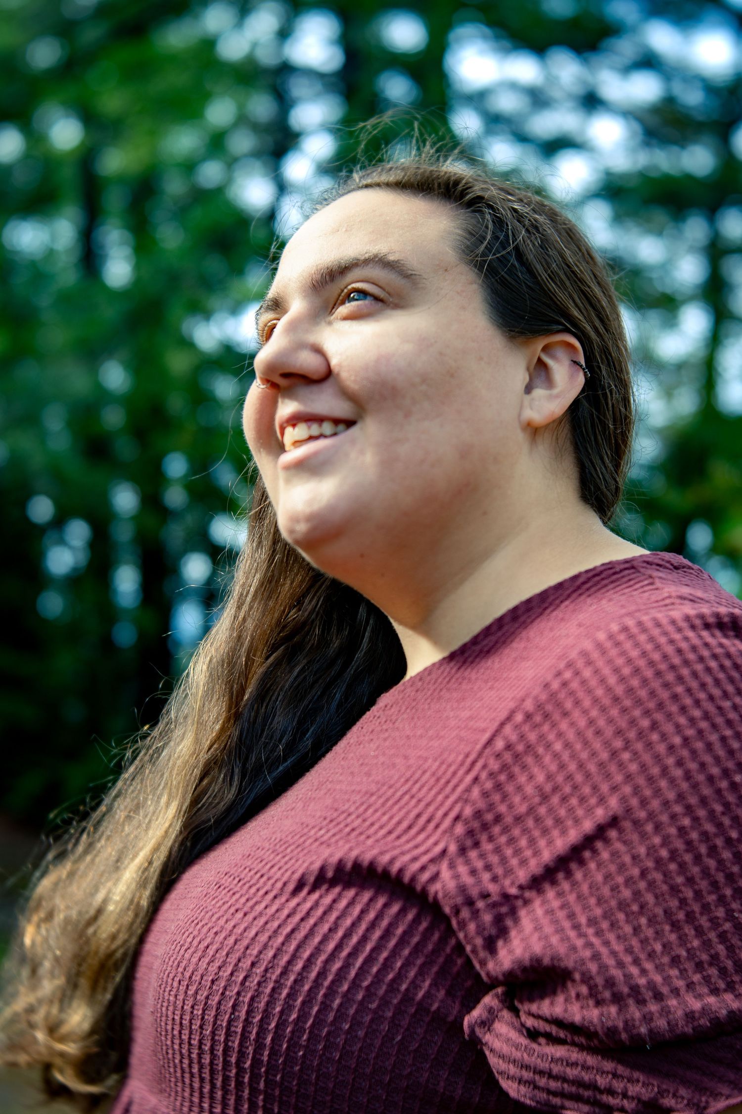A sequence of upward-looking shots in a forest setting with someone wearing a maroon knit sweater.