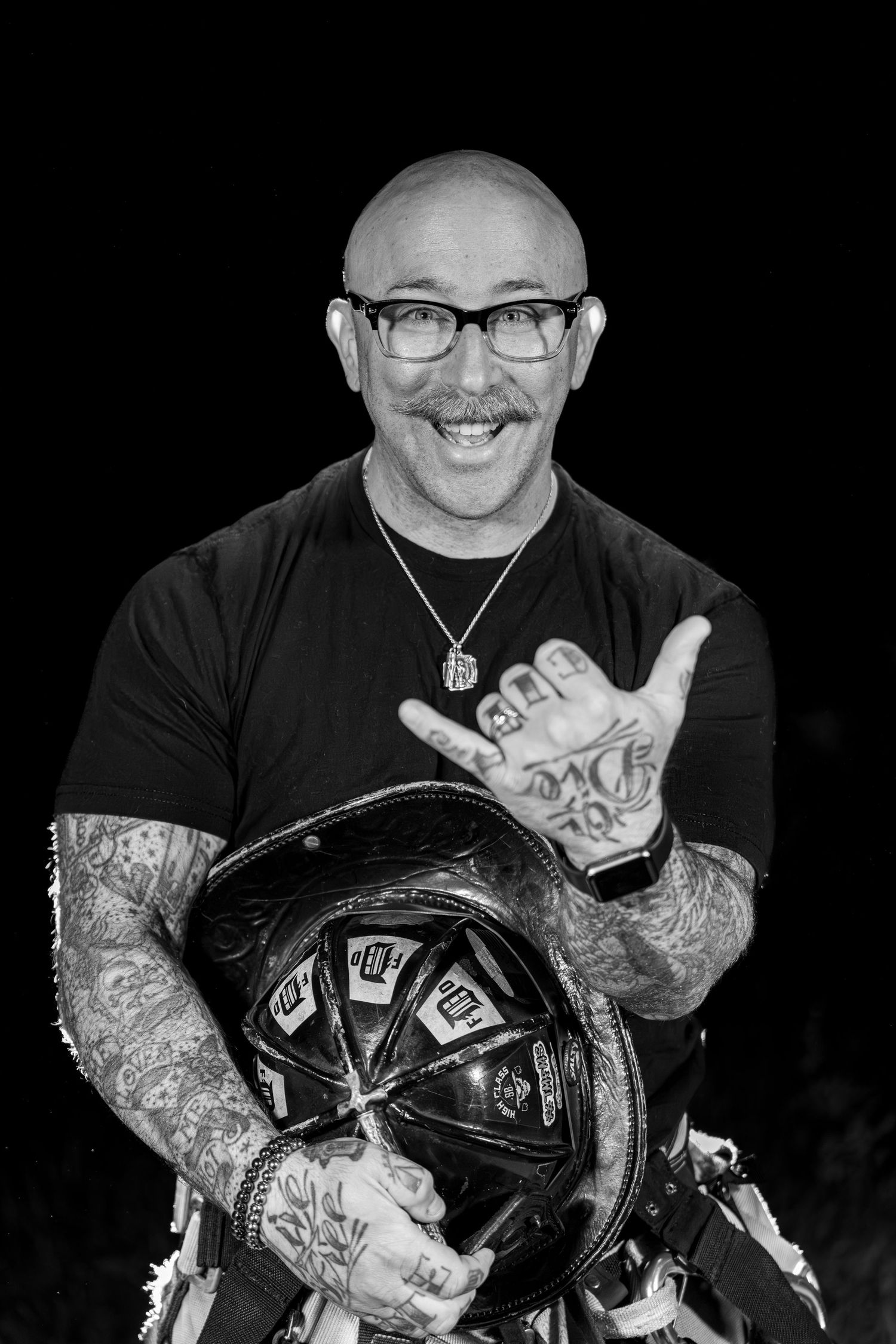 A series of black and white photos showing someone with tattooed arms holding and displaying a motorcycle helmet.