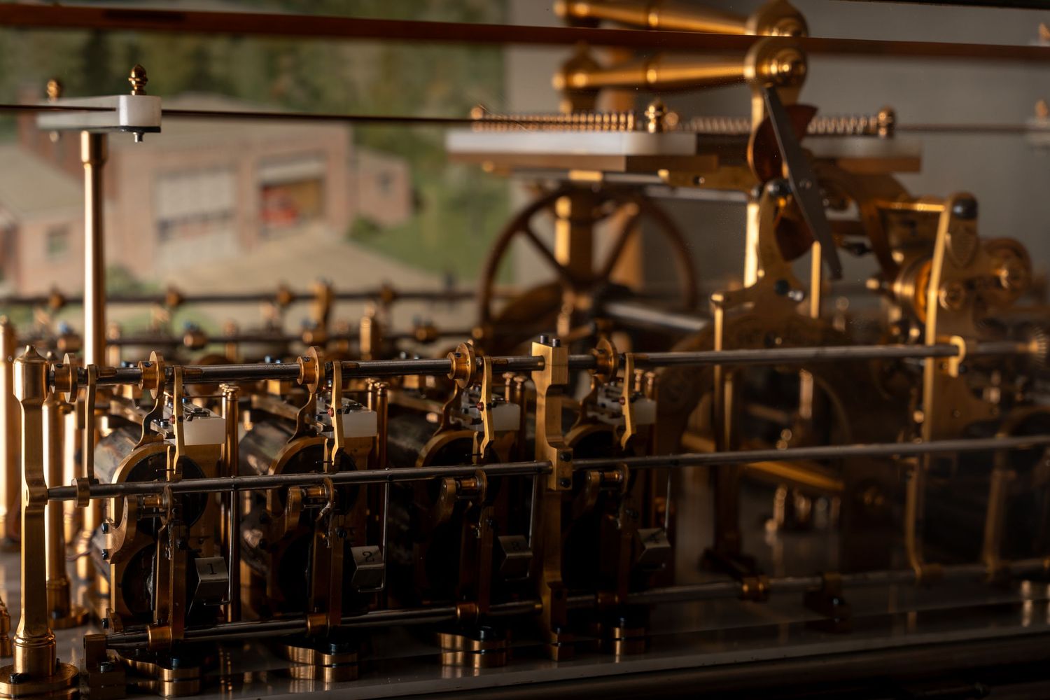 Intricate brass and steel vintage mechanical engine model displayed in a museum exhibit.