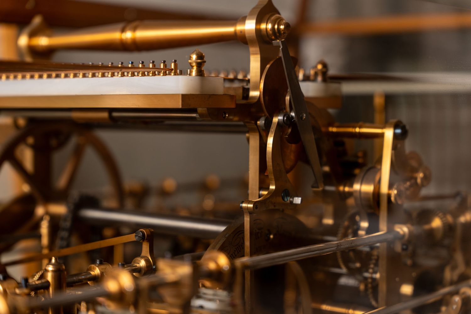 Intricate antique brass mechanical clock or automaton mechanism with gears and levers in golden detail.