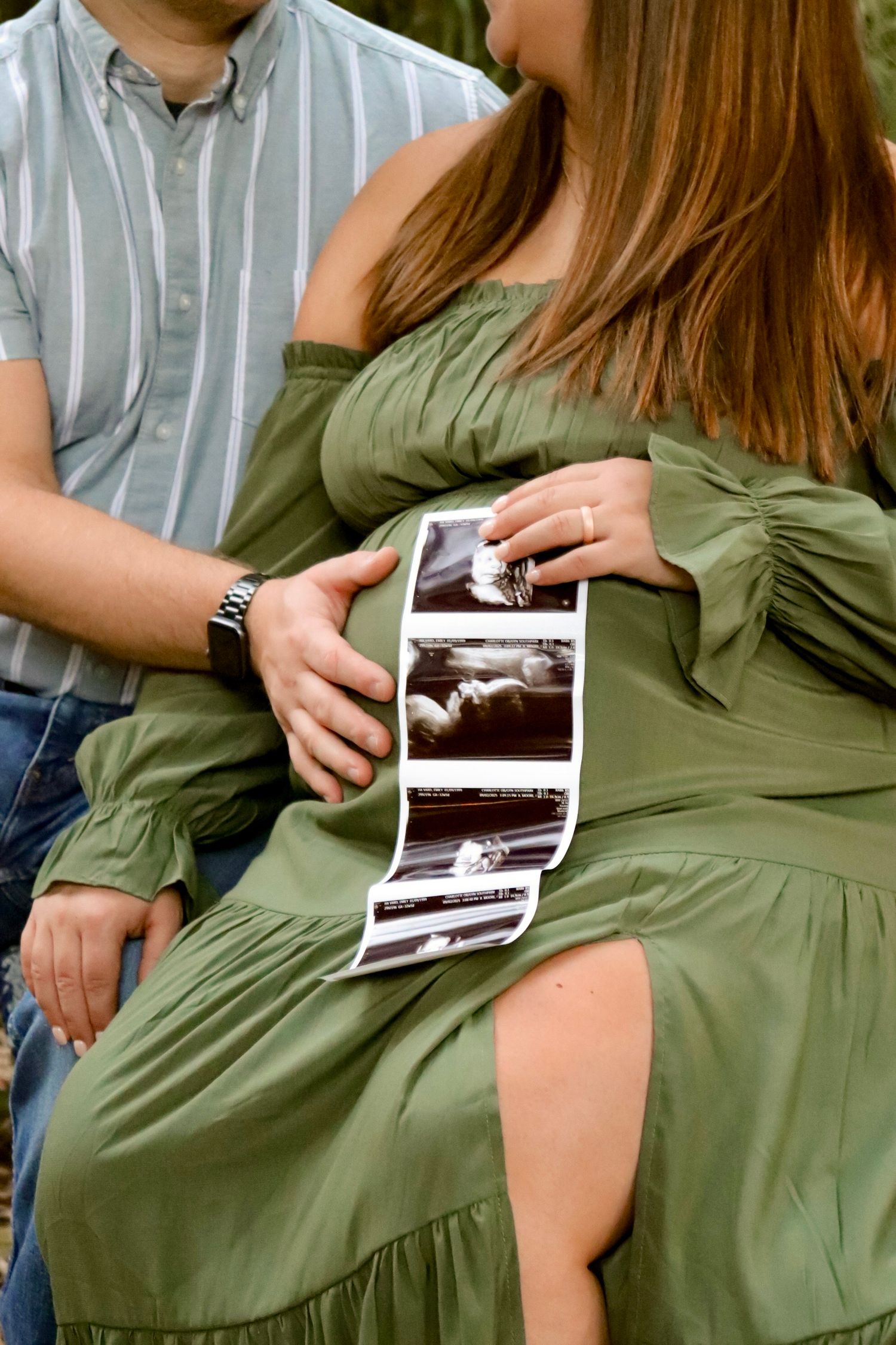 close-up of a couple sitting together holding an ultra-sound during a maternity session.