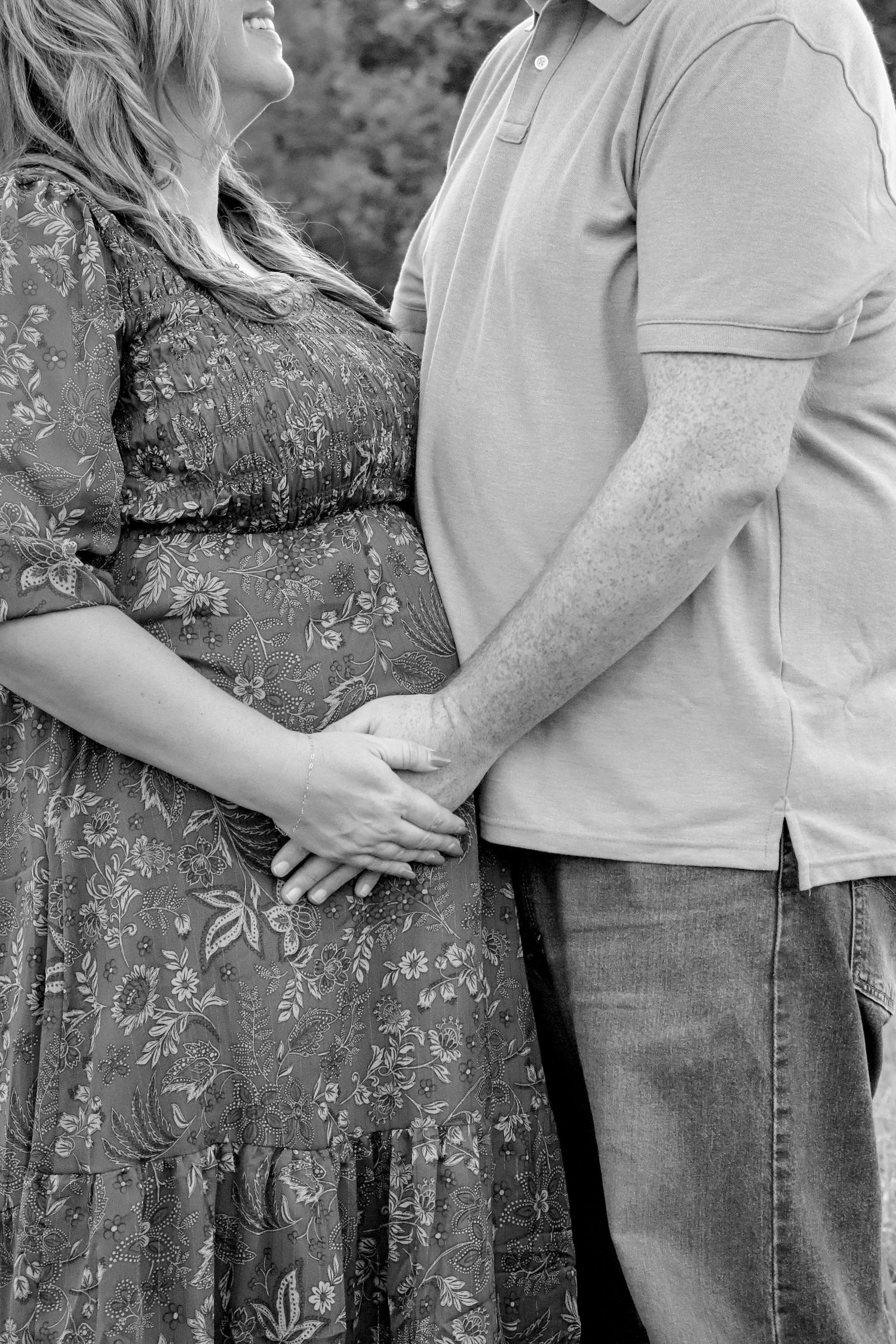 close-up of a couple holding hands during a maternity session.