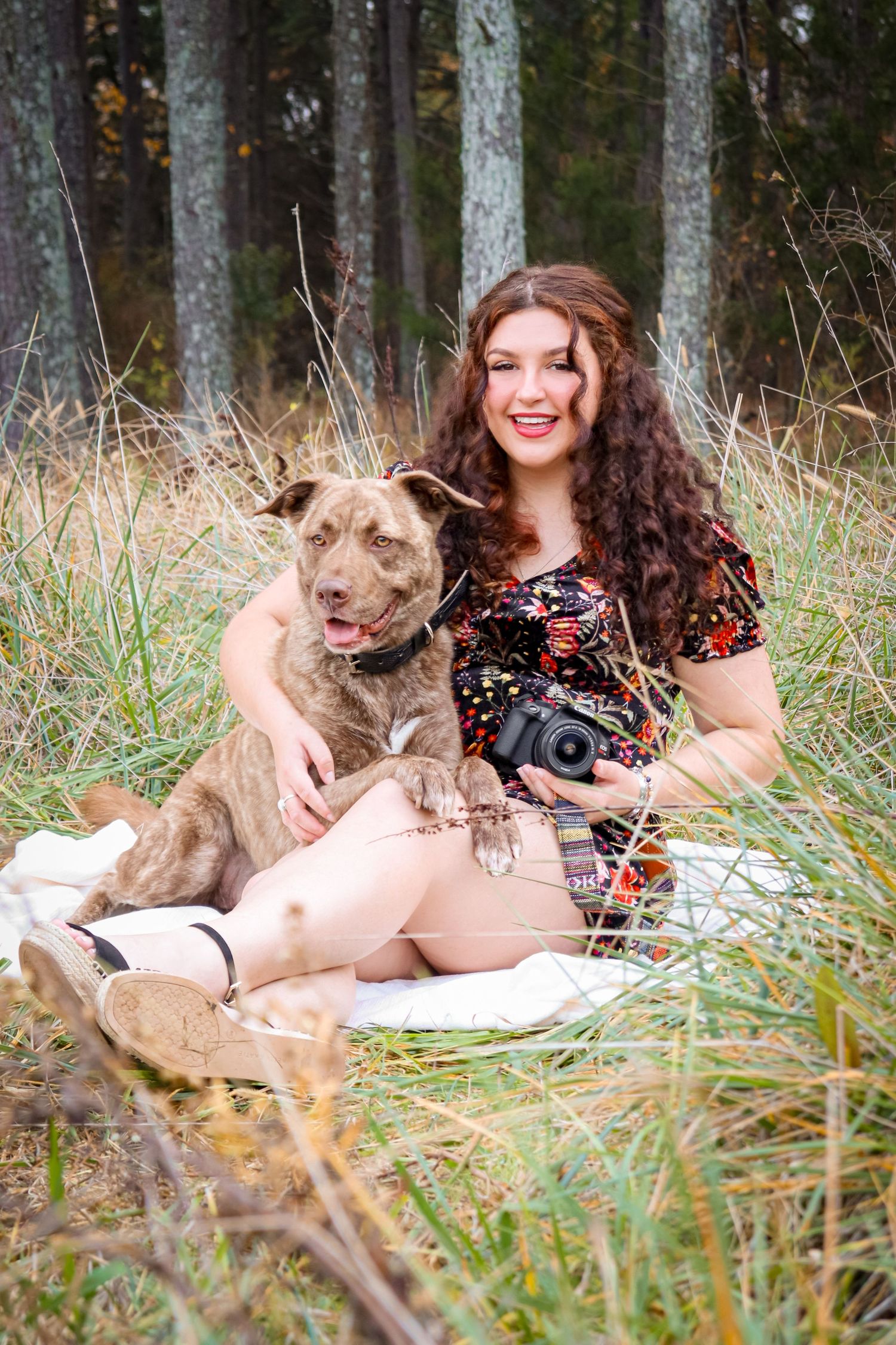 Portrait of a girl and her dog, taken outdoors in warm natural light.