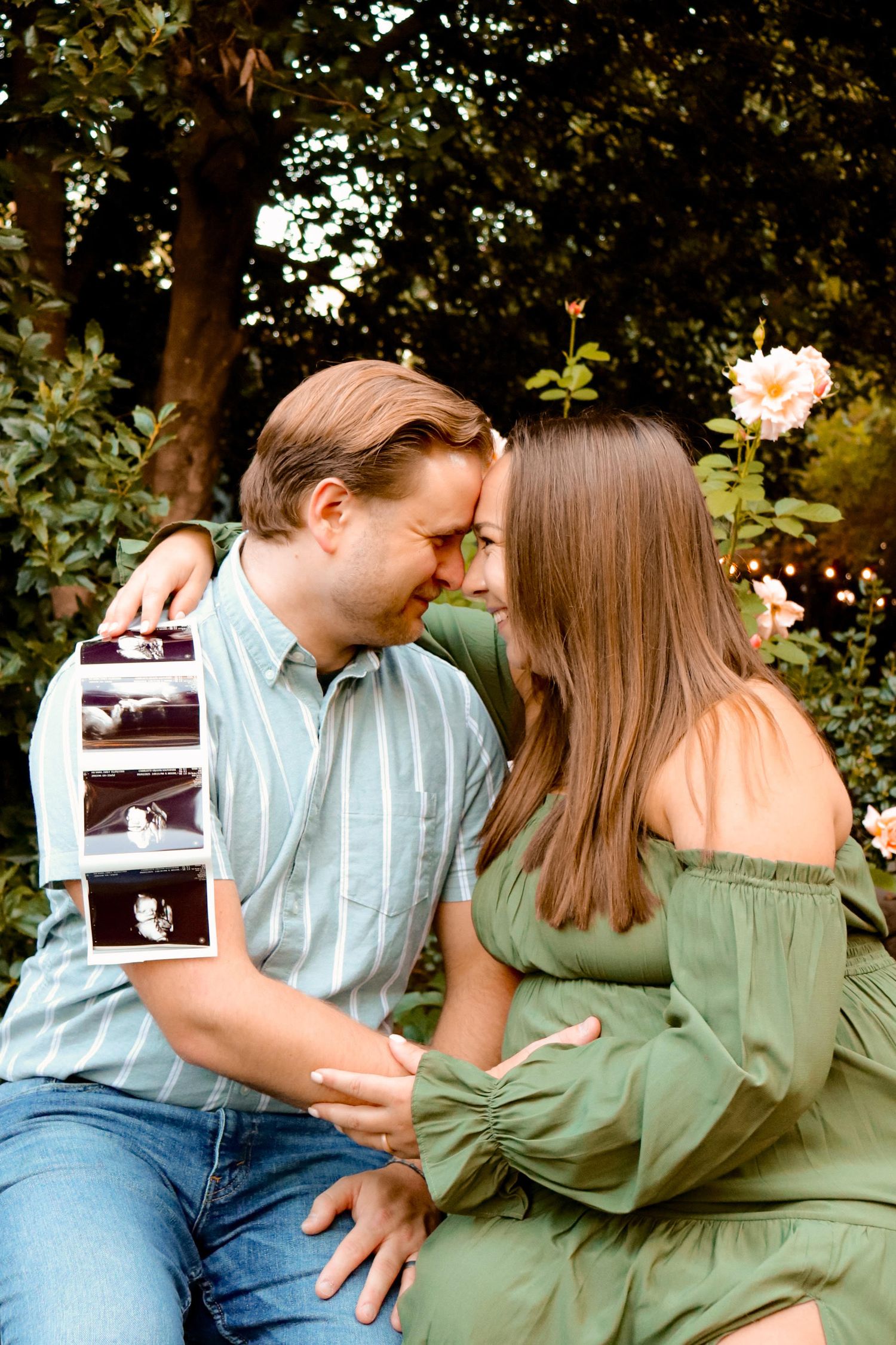 portrait of a couple sitting together white holding an ultra-sound during a maternity session.